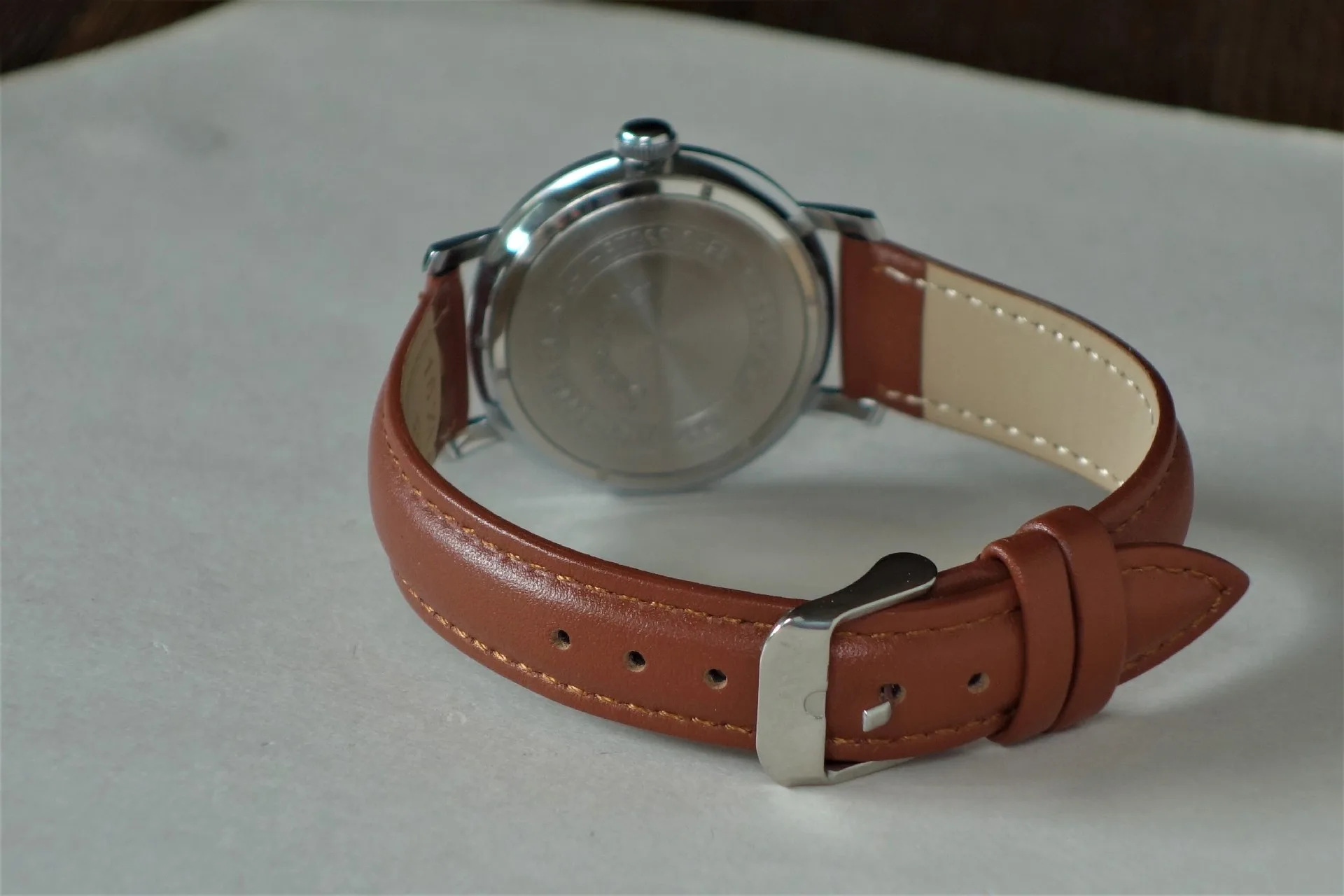 Armbanduhr braunes Lederarmband Armbanduhr mit braunem Lederarmband und silberfarbenem Gehäuseboden.