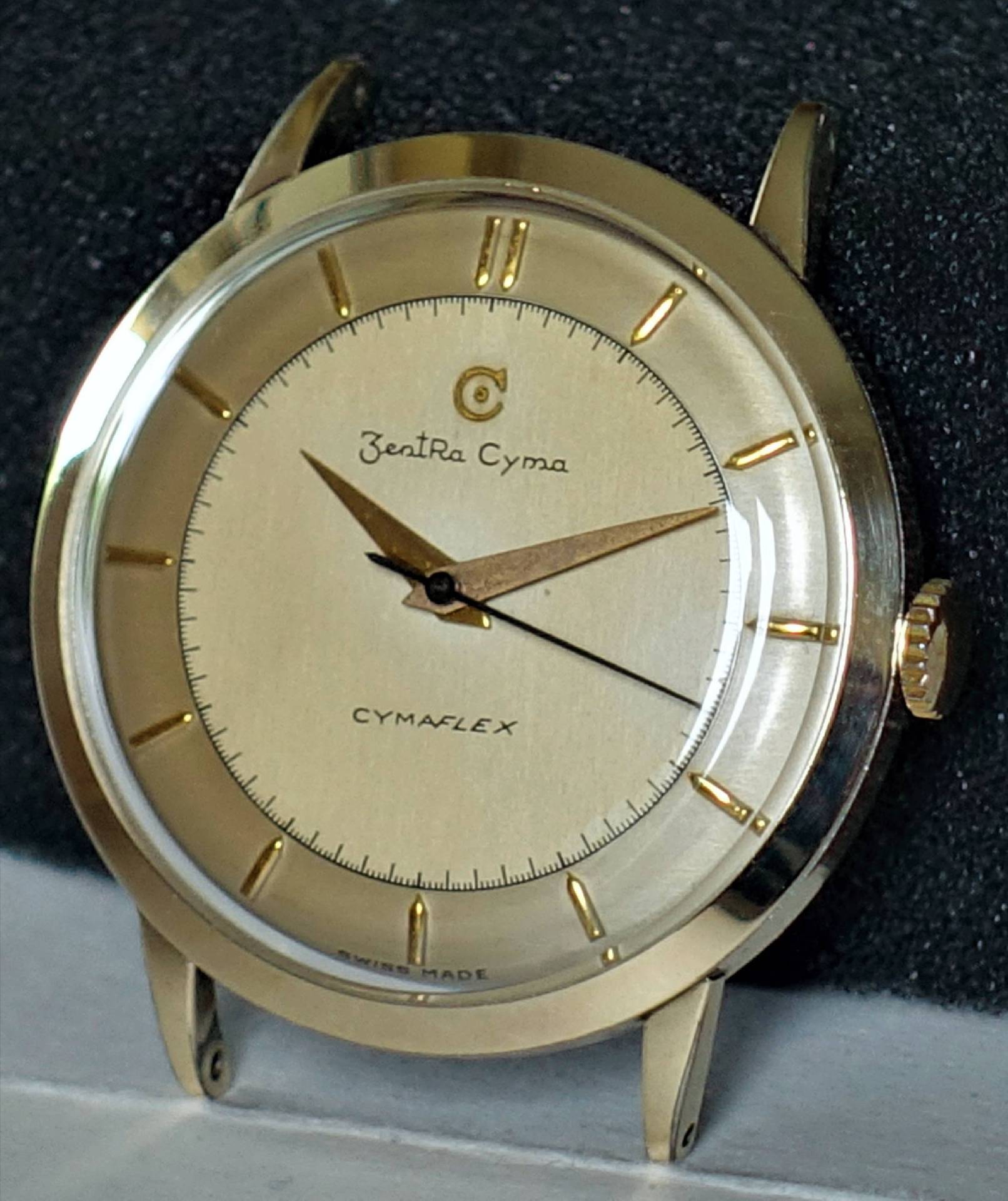 Goldfarbene Armbanduhr mit hellem Zifferblatt und goldfarbenen Zeigern.