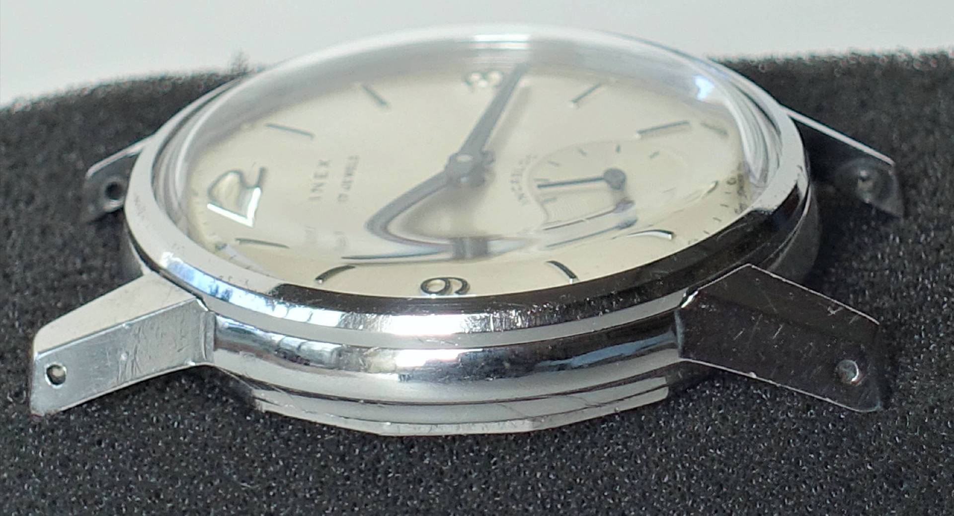 Detailaufnahme einer Inex Armbanduhr mit silbernem Ziffernblatt und verchromtem Gehäuse