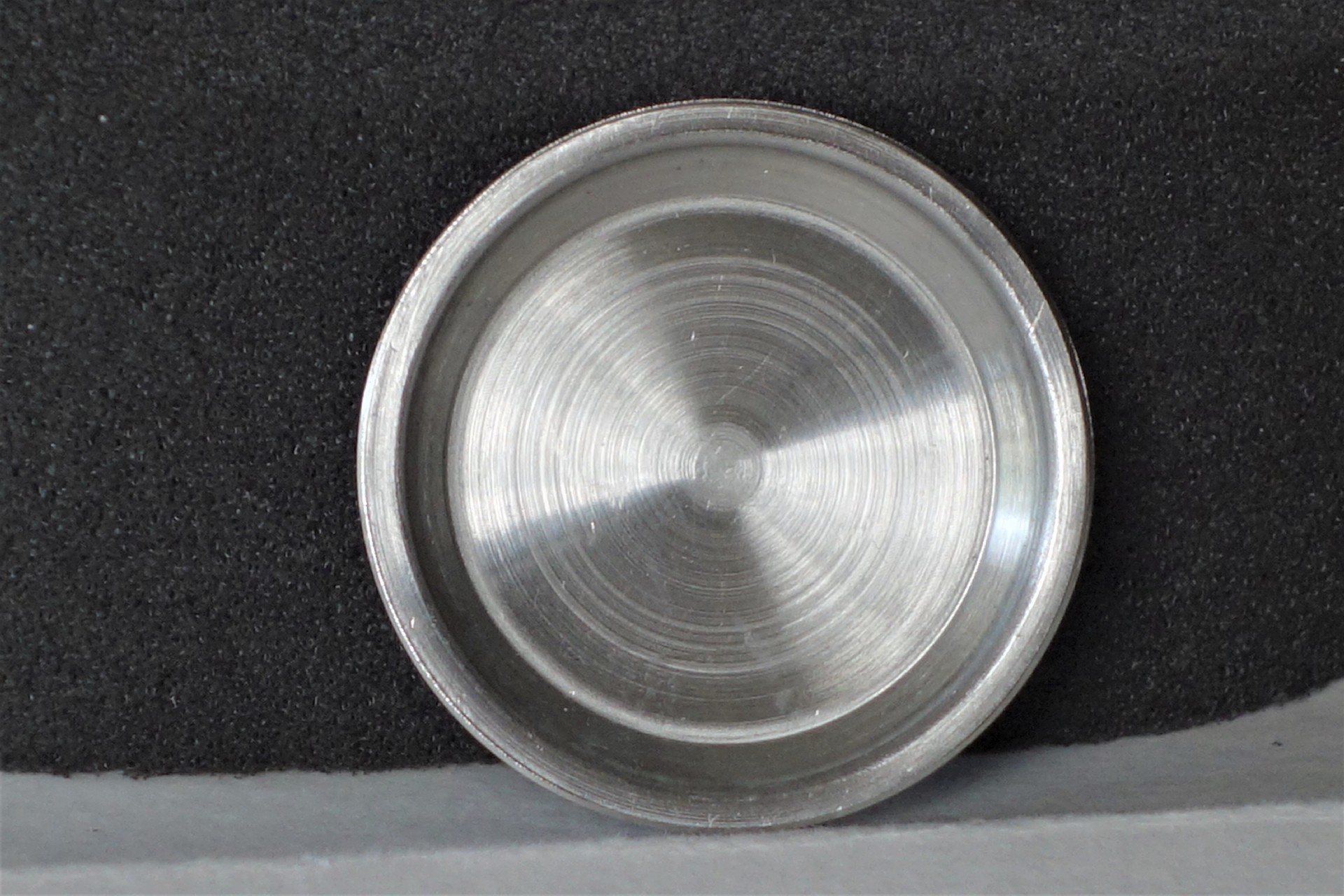 Runder silberfarbener Gehäuseboden für Armbanduhren.