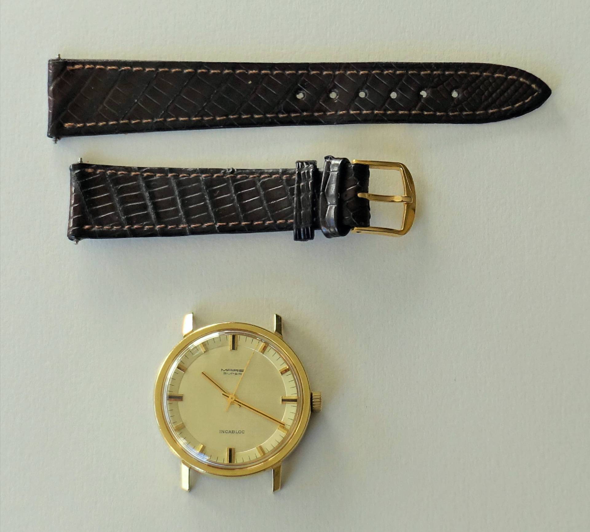 Zerlegte Murex Armbanduhr mit goldfarbenem Gehäuse und braunem Armband.