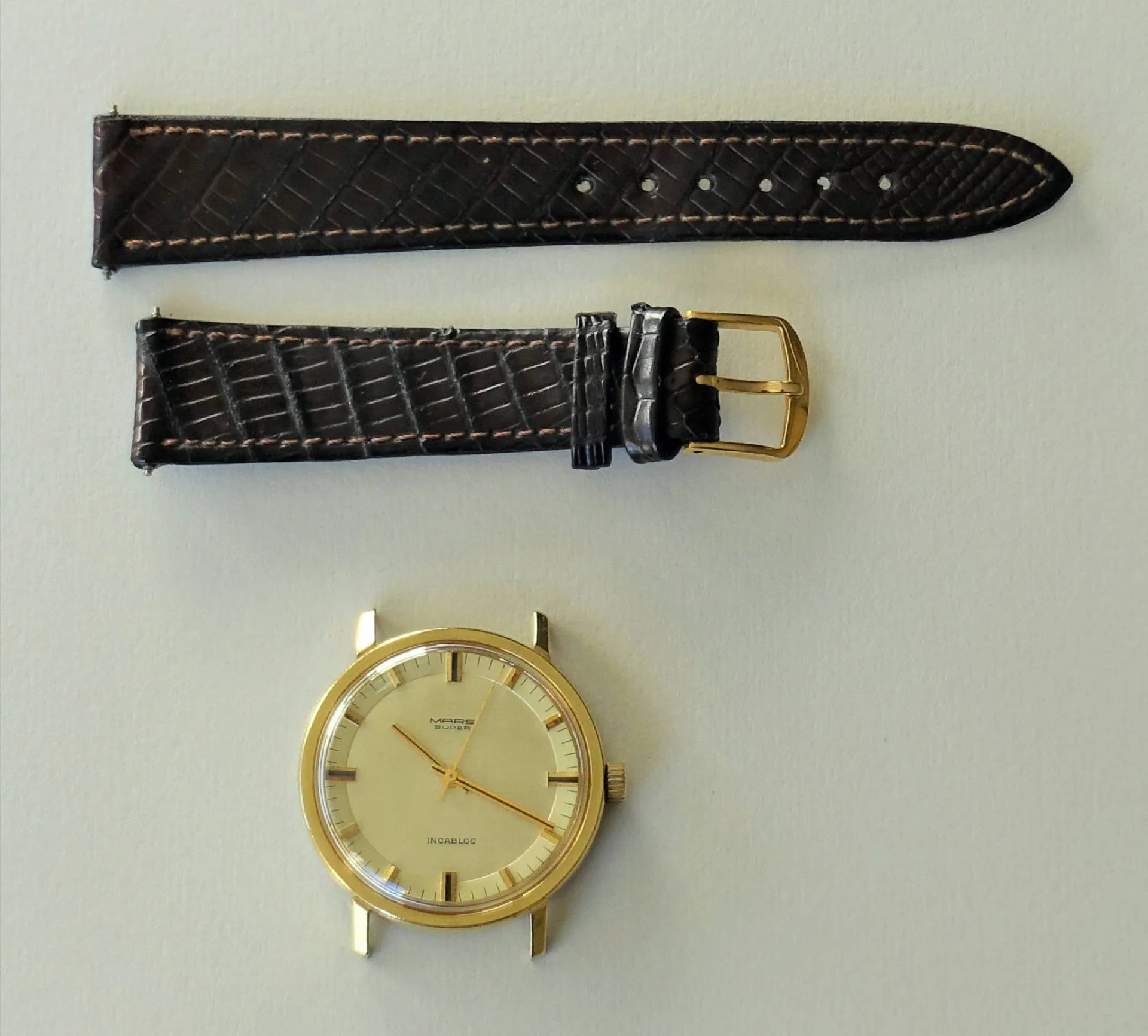 Zerlegte Murex Armbanduhr mit goldfarbenem Gehäuse und braunem Armband.
