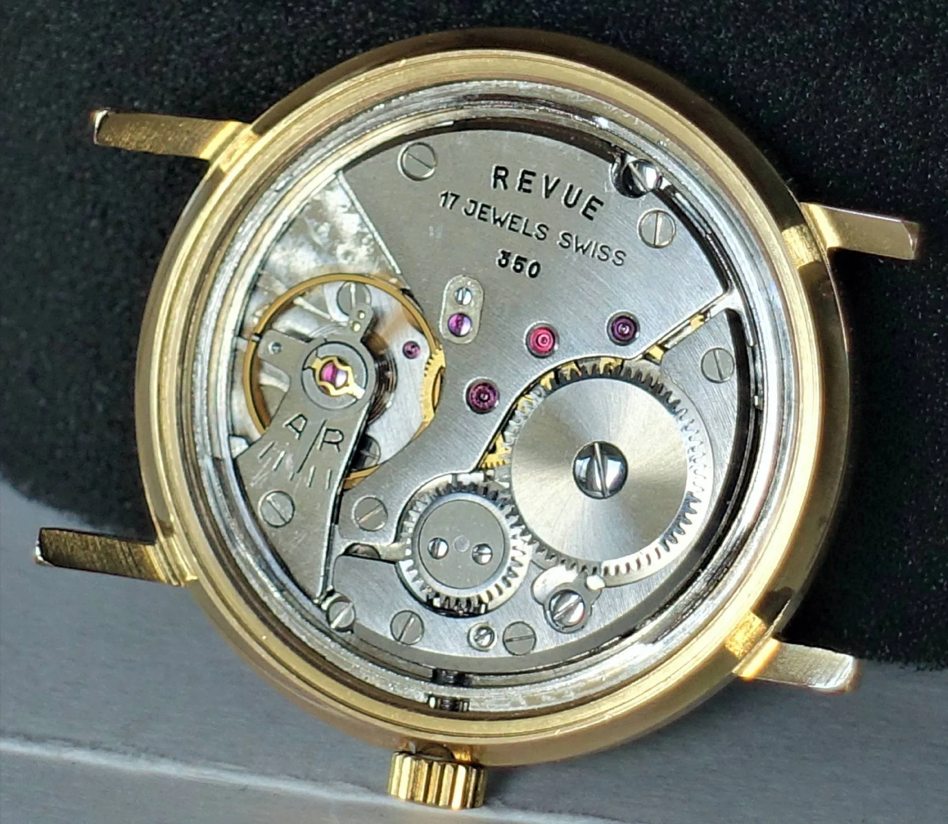 Revue Uhrwerk 850 Mechanisches Uhrwerk Revue 850 mit sichtbaren Zahnrädern und goldfarbenem Gehäuse.