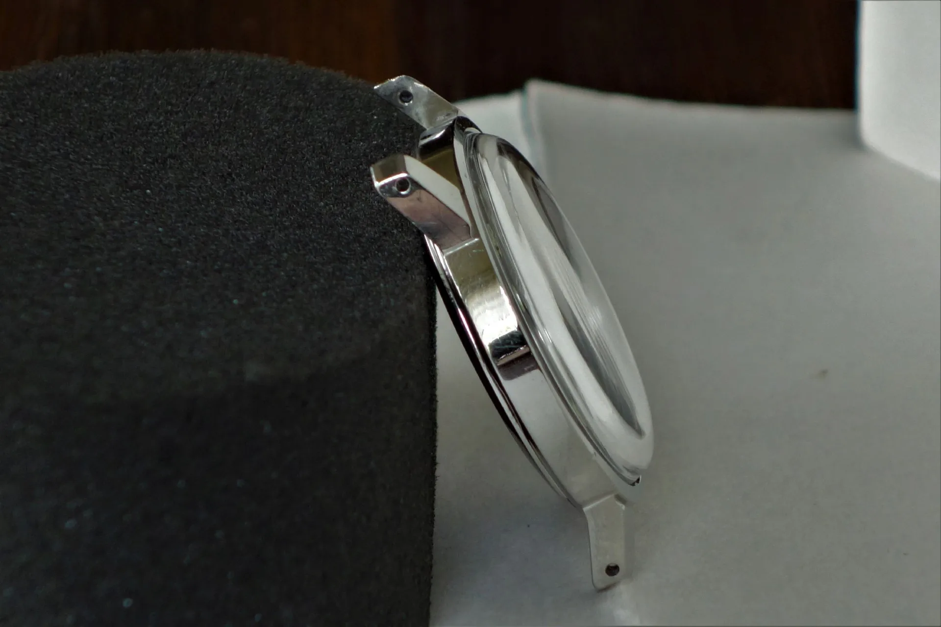 Uhrengehäuse silberfarben Silberfarbenes Uhrengehäuse mit montiertem Glas, seitliche Ansicht.