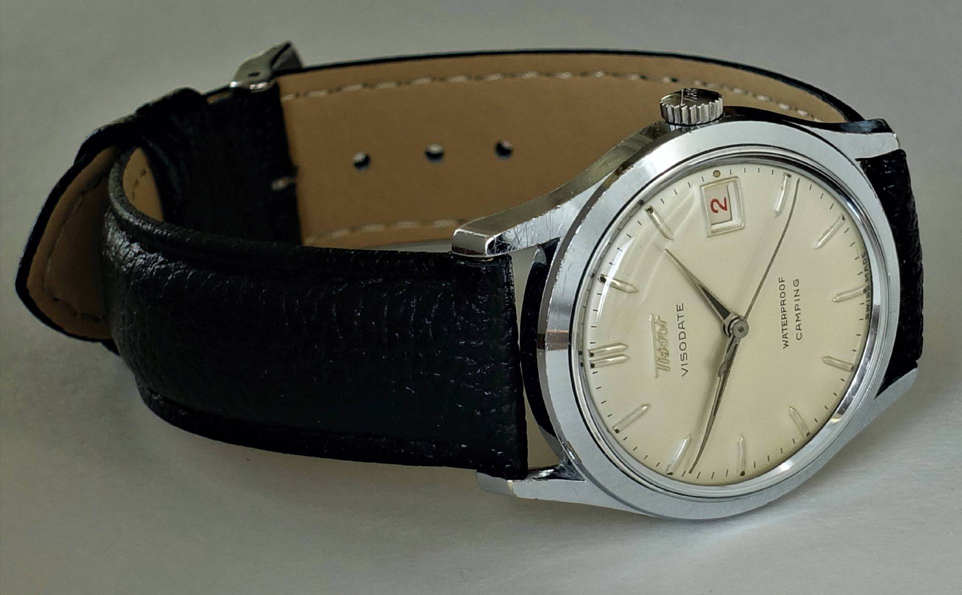 Silberfarbene Armbanduhr mit beigem Zifferblatt und schwarzem Armband.