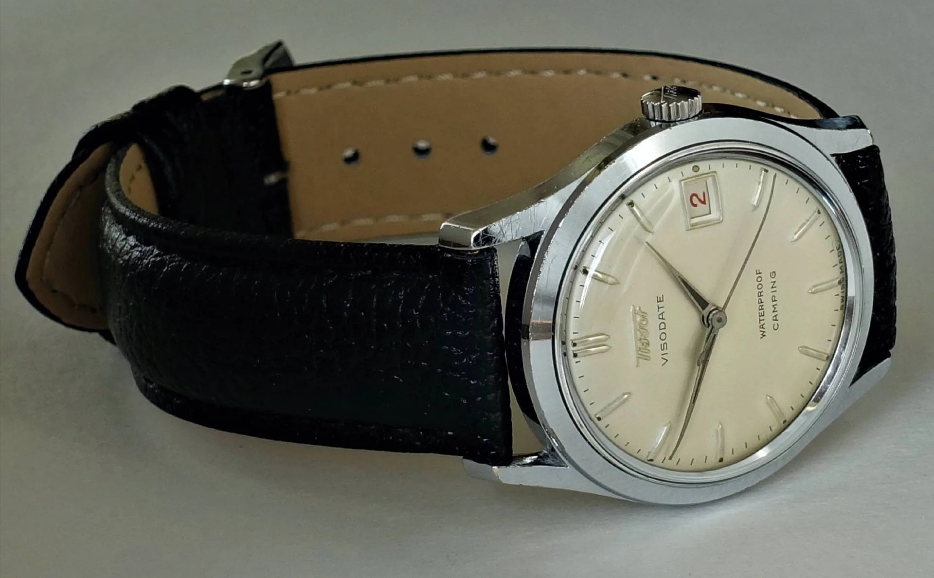 Tissot Visodate Armbanduhr Silberfarbene Armbanduhr mit beigem Zifferblatt und schwarzem Armband.