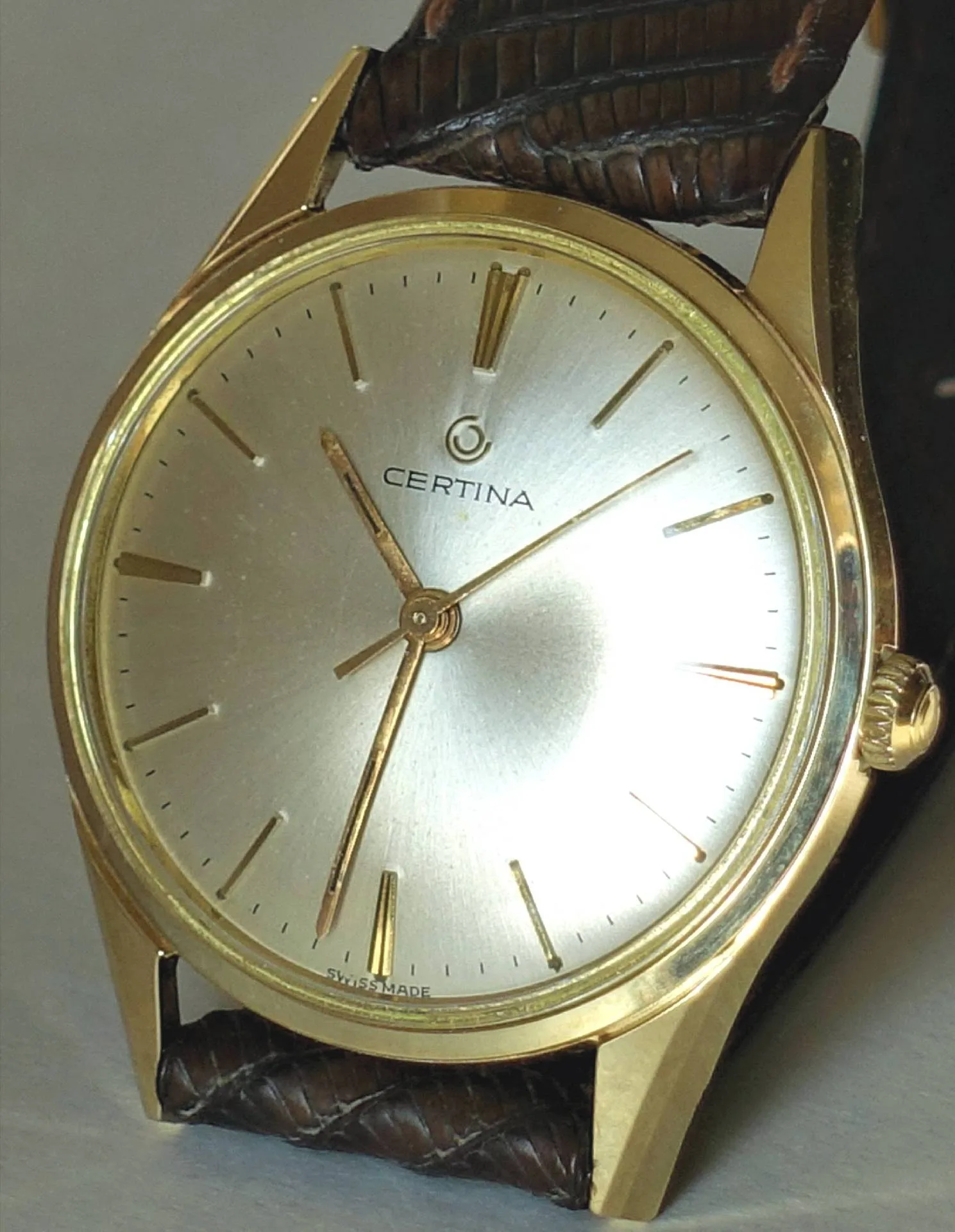 Certina Armbanduhr goldfarben Goldfarbene Certina Armbanduhr mit hellem Zifferblatt und braunem Armband.