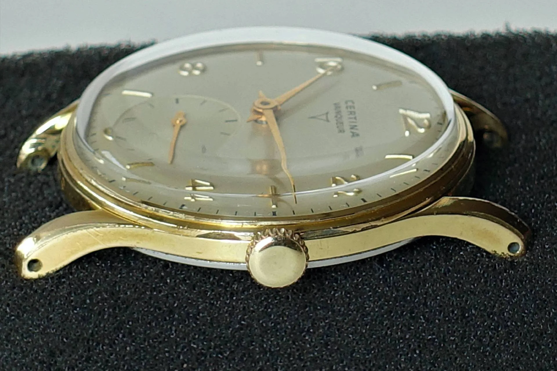 Goldfarbene Armbanduhr mit hellem Zifferblatt und goldfarbenen Zeigern.
