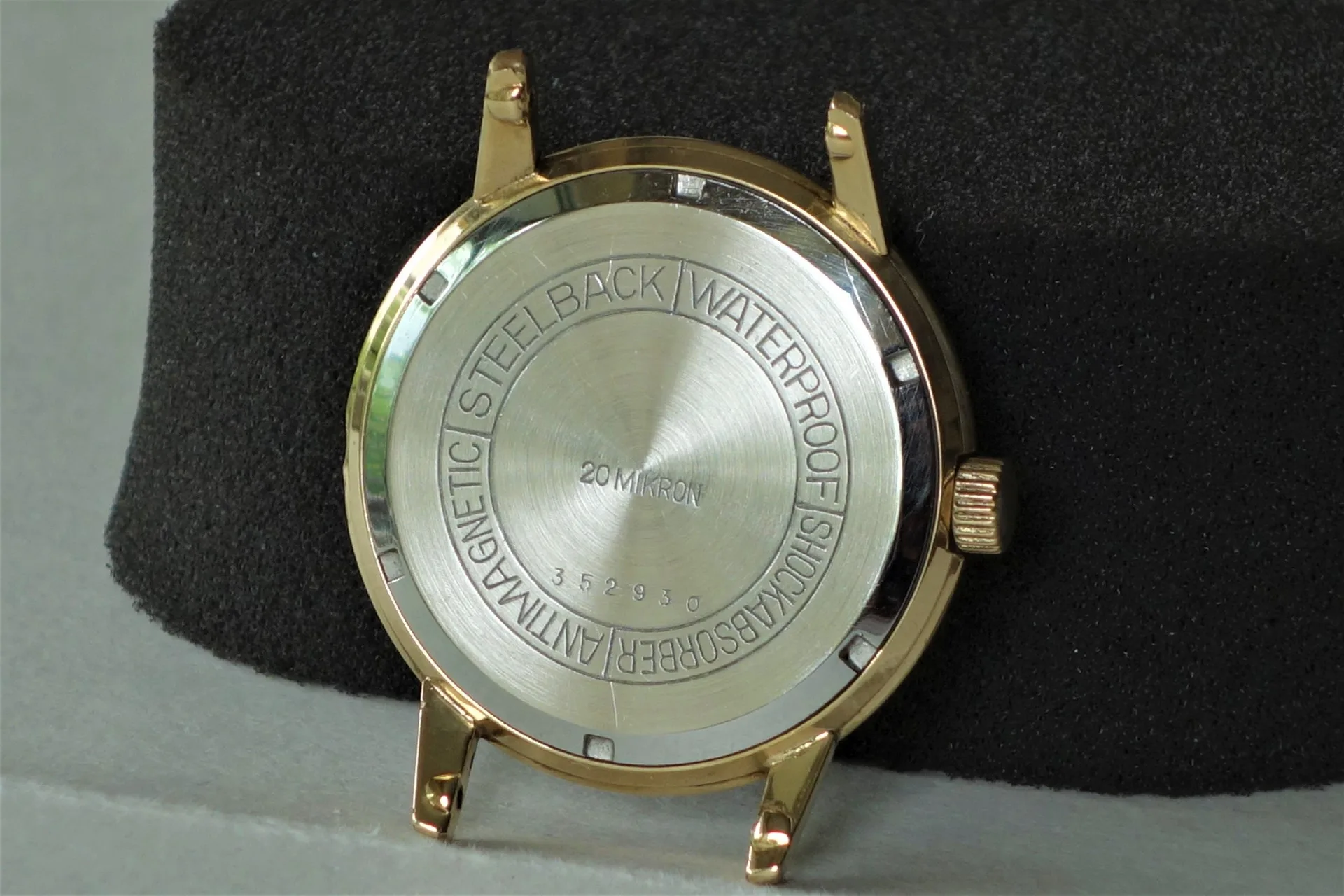 Goldfarbenes Uhrengehäuse mit silberfarbener Rückseite und seitlicher Krone.