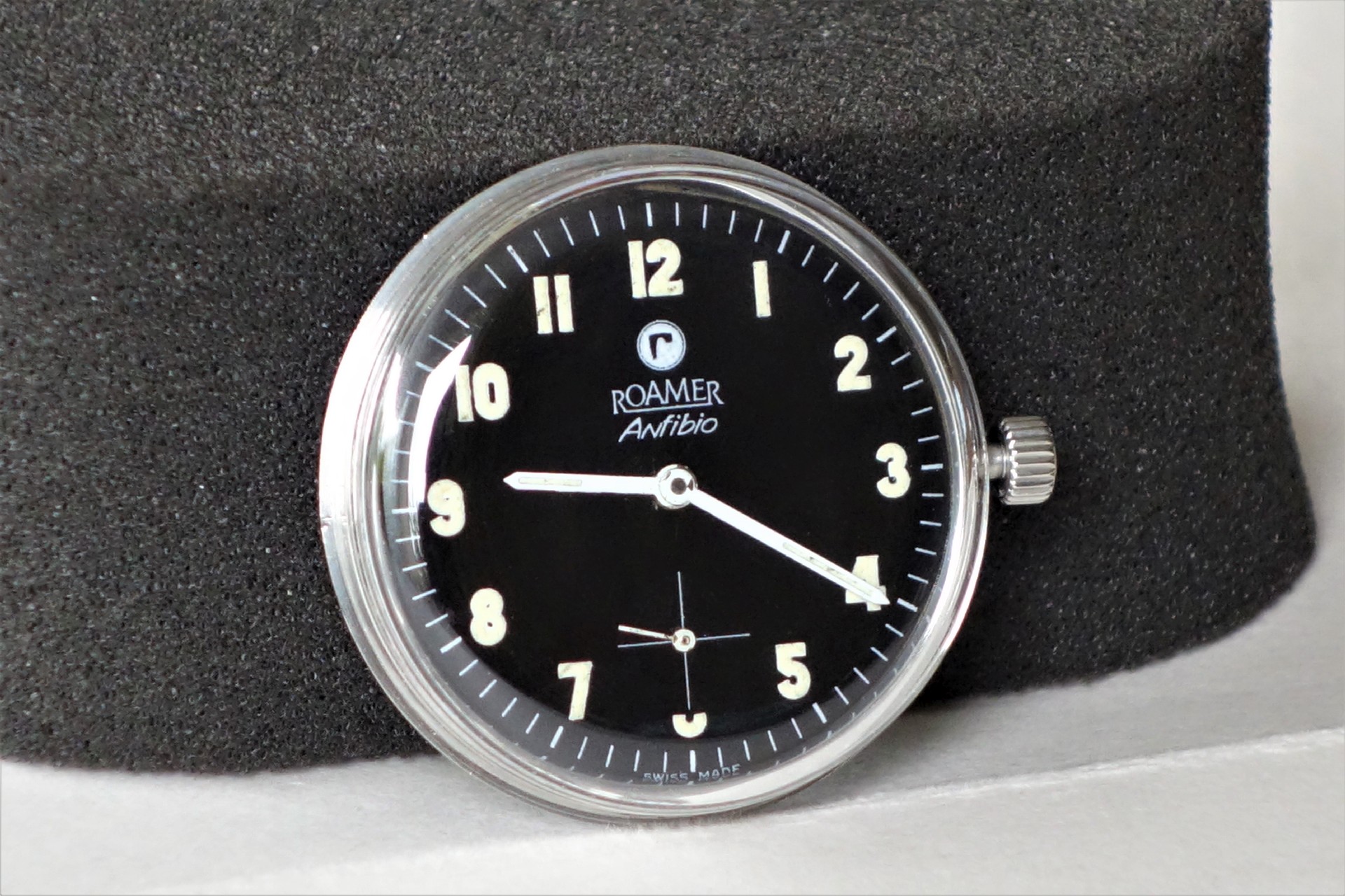 Schwarzes Uhrwerk mit Zifferblatt und silberfarbener Krone, Modell Roamer Anfibio.