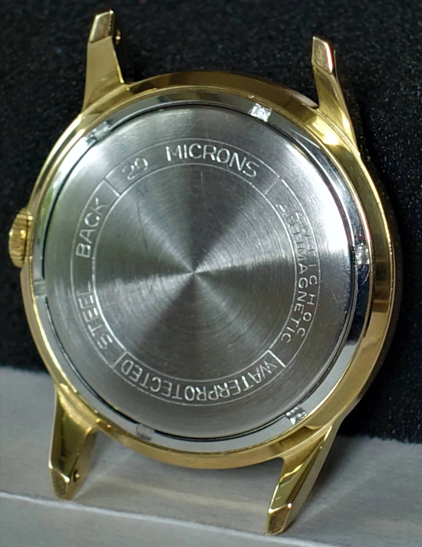 Gehäuse goldfarben mit Boden Rundes goldfarbenes Uhrgehäuse mit silberfarbener Rückseite.