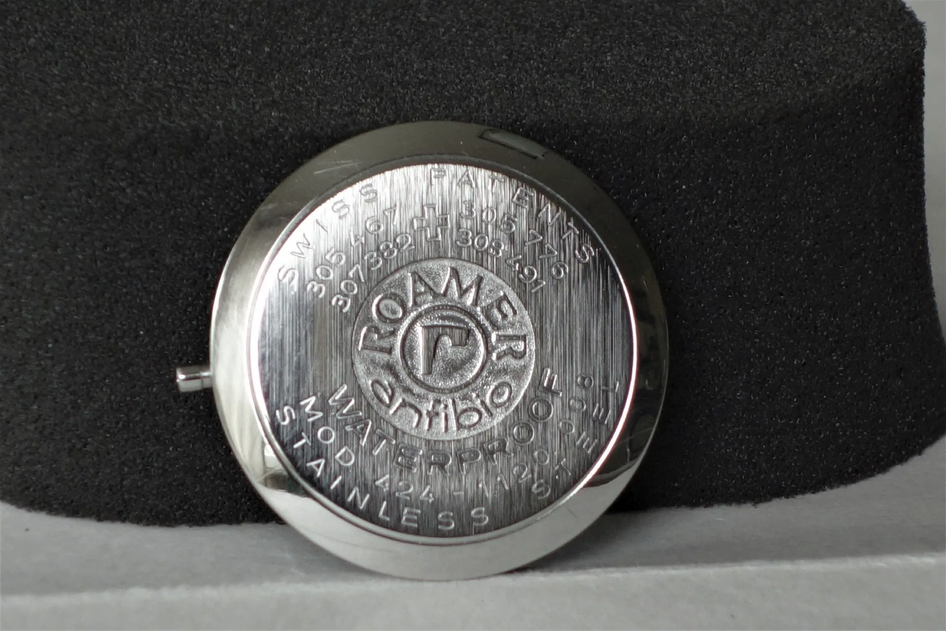 Runder silberfarbener Gehäuseboden mit eingraviertem Roamer-Logo und Schriftzug.
