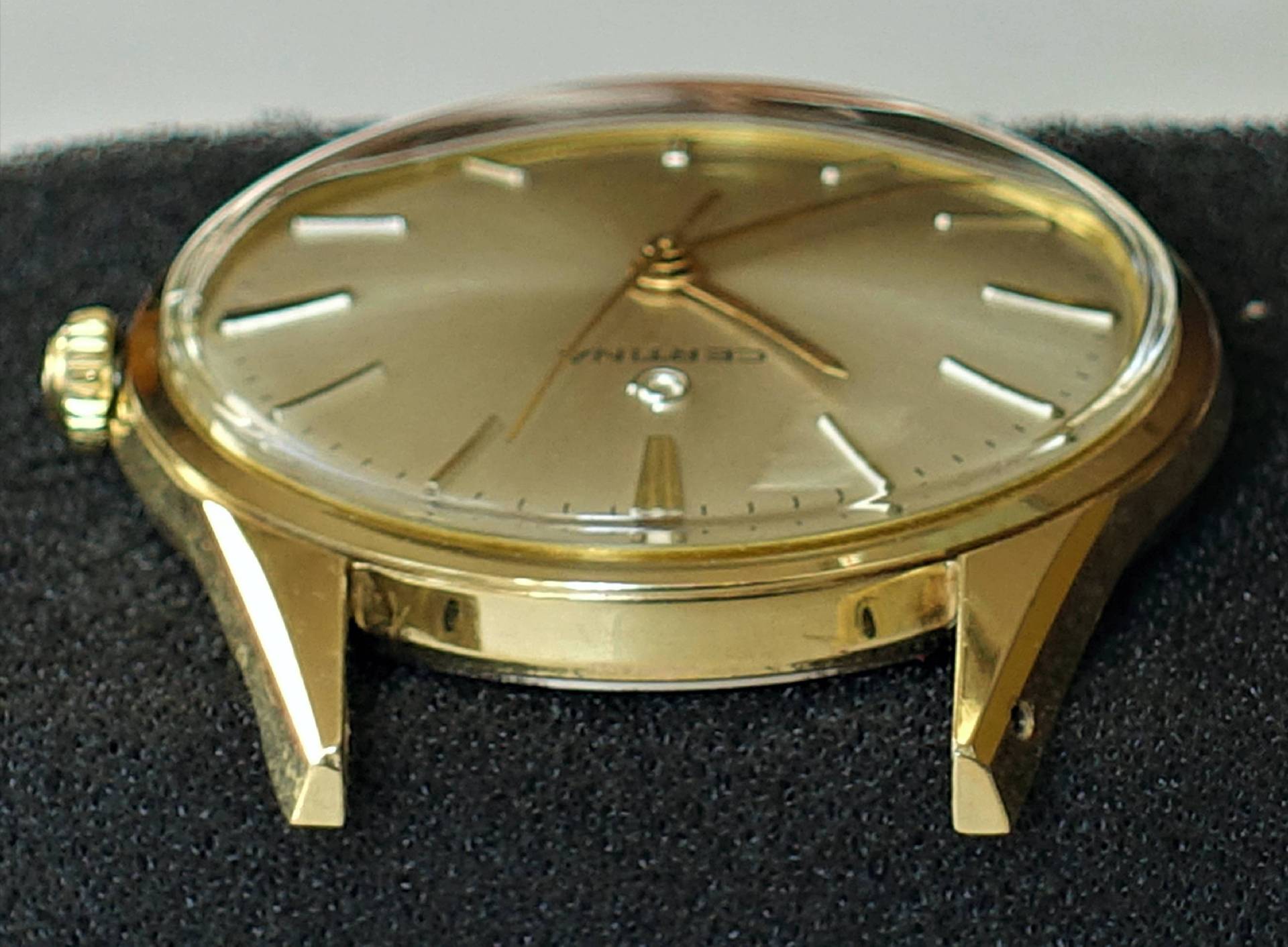 Goldfarbene Armbanduhr mit schlichtem Zifferblatt und Metallgehäuse.