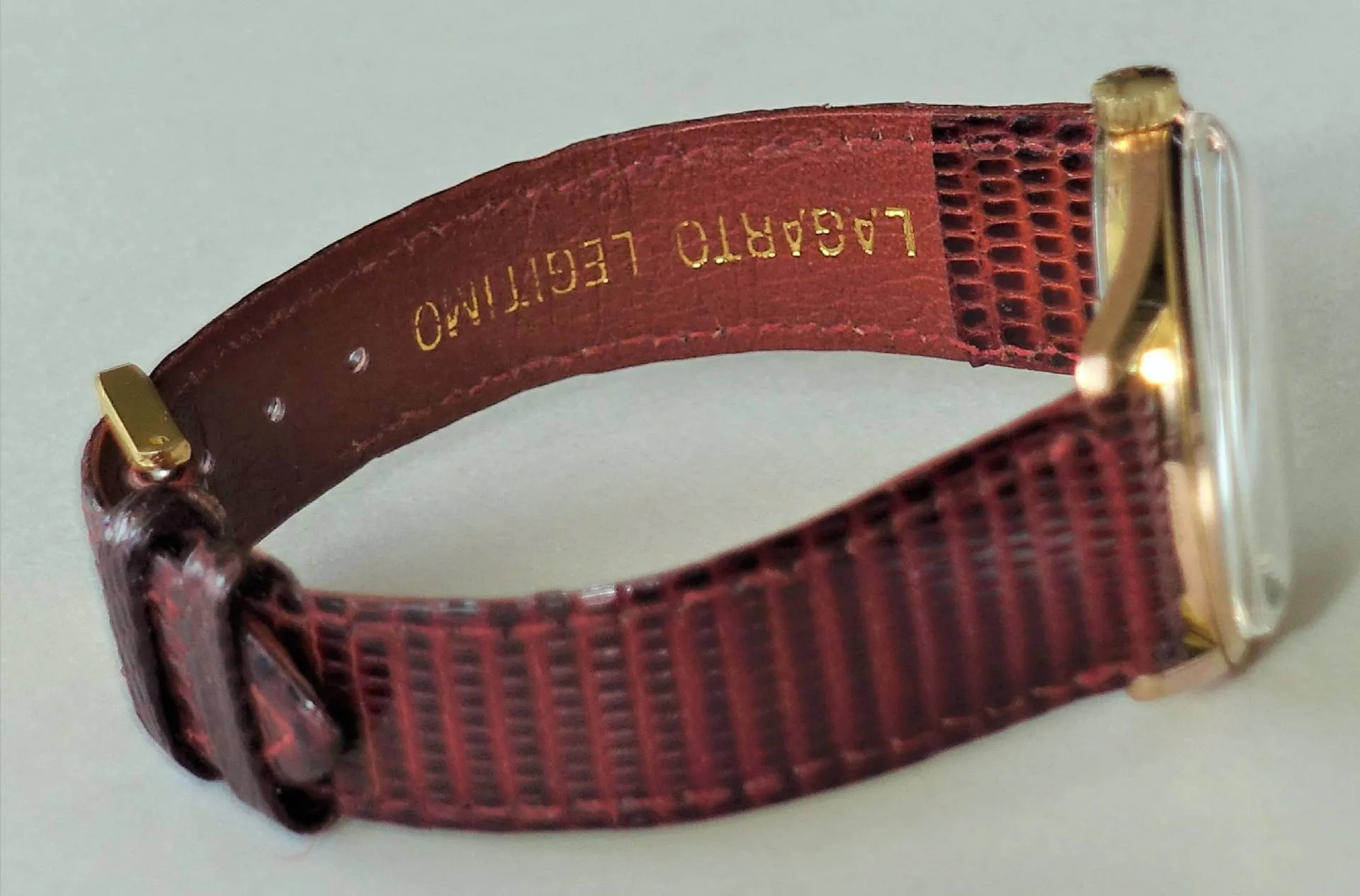 Braune Armbanduhr mit goldfarbenem Gehäuse und strukturiertem Lederarmband.