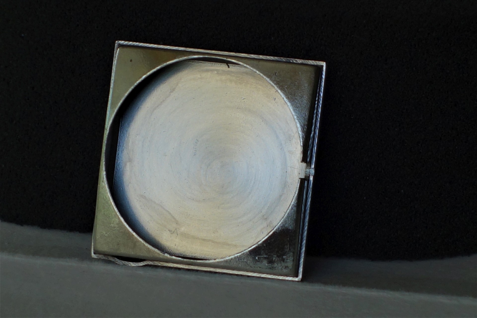 Quadratischer Gehäuseboden aus Metall für Armbanduhren.