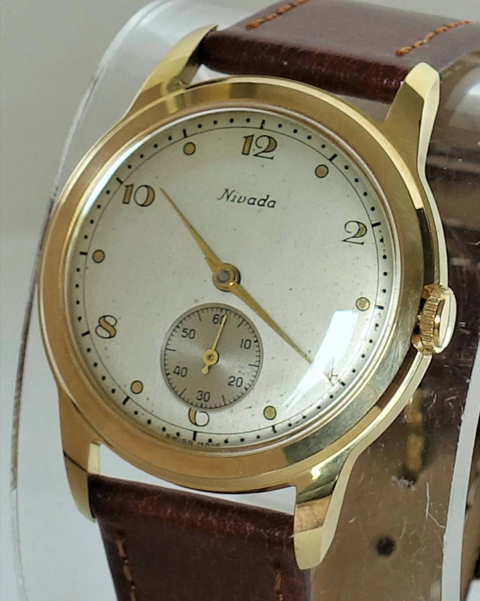 Armbanduhr goldfarben braunes Band Goldfarbene Armbanduhr mit hellem Zifferblatt und braunem Lederarmband.