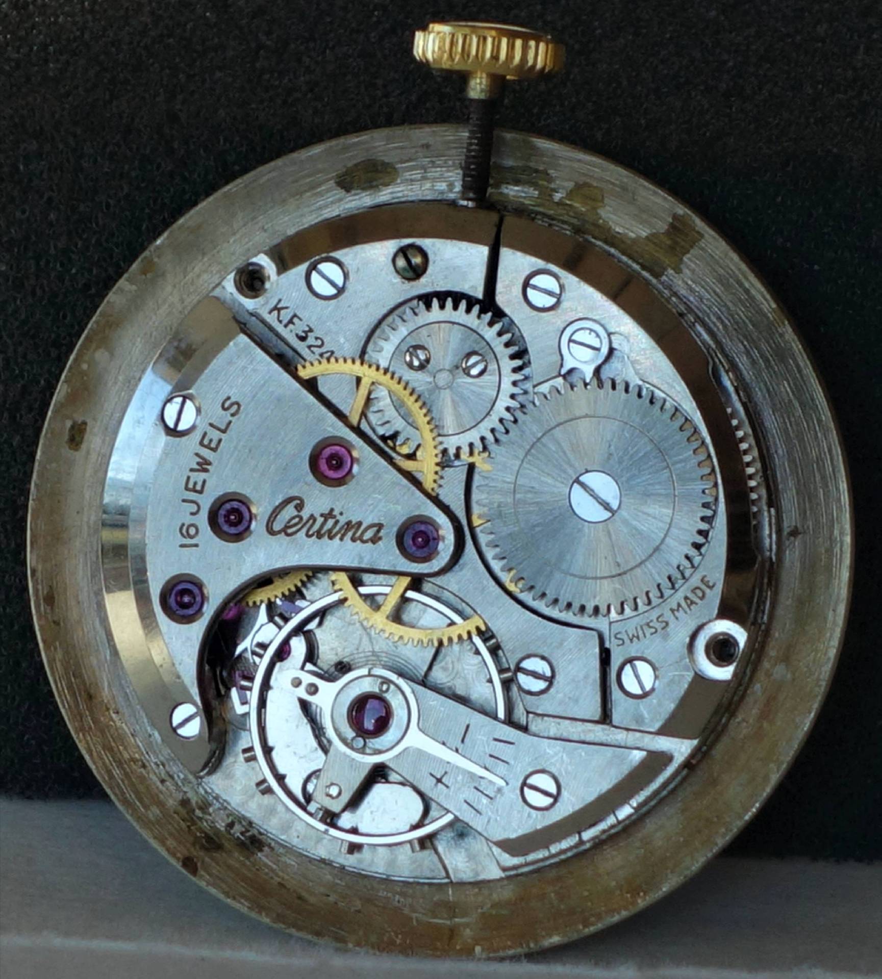 Mechanisches Uhrwerk von Certina mit sichtbaren Zahnrädern und goldfarbener Krone.