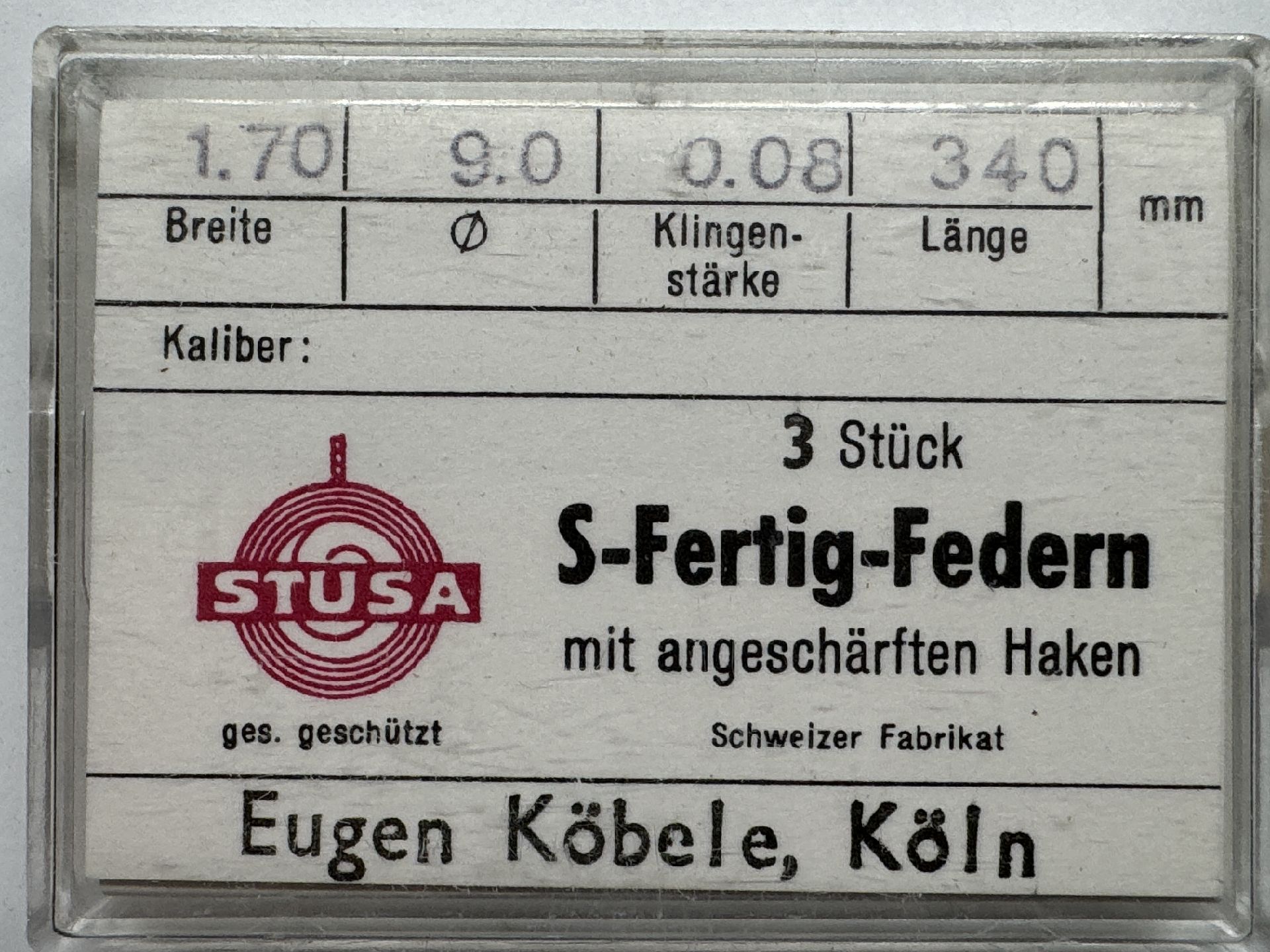 Set mit drei S-Fertig-Federn für Uhren mit angeschärften Haken in transparenter Verpackung.