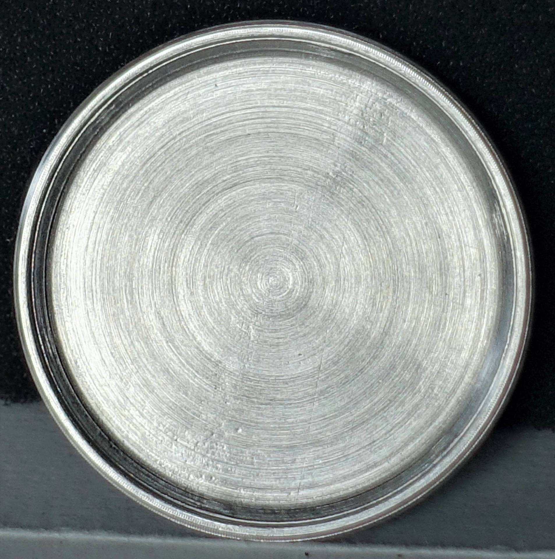 Runder silberfarbener Gehäuseboden für Armbanduhren.