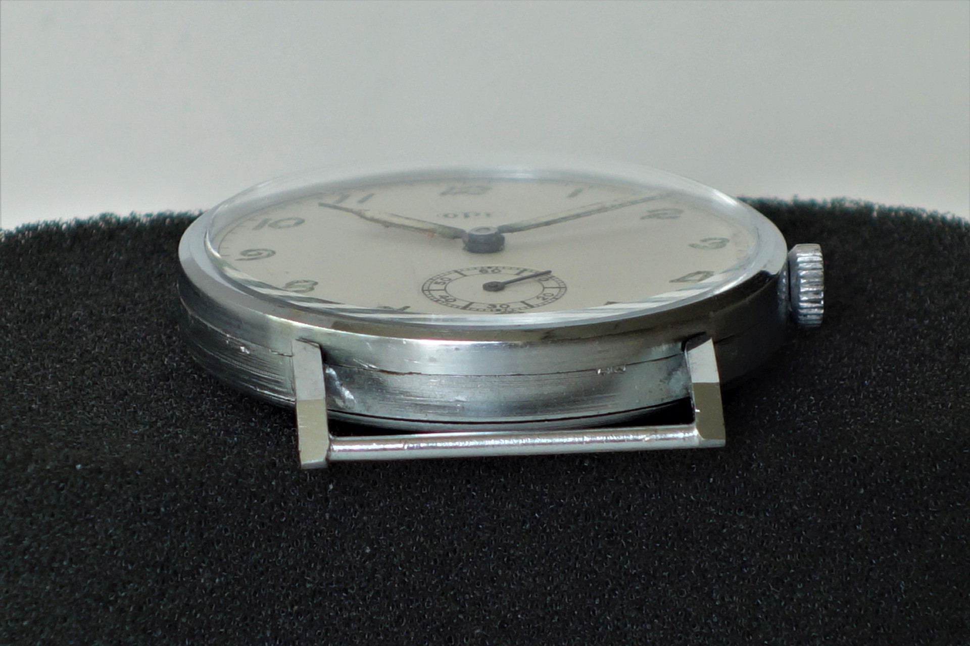 Flache silberfarbene Armbanduhr mit weißem Zifferblatt und kleiner Sekunde.