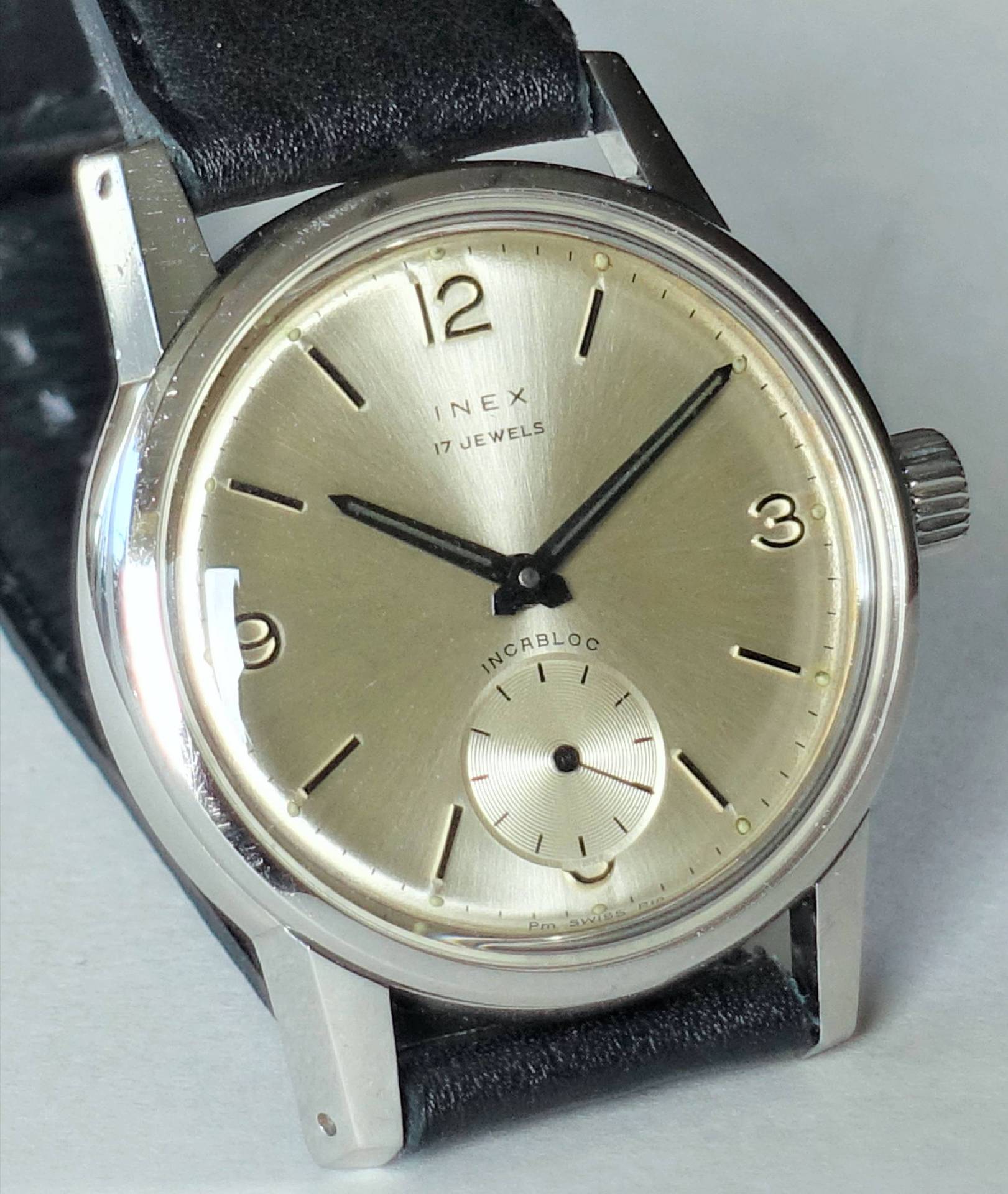 Inex Armbanduhr mit leicht glänzendem Zifferblatt und schwarzem Lederarmband