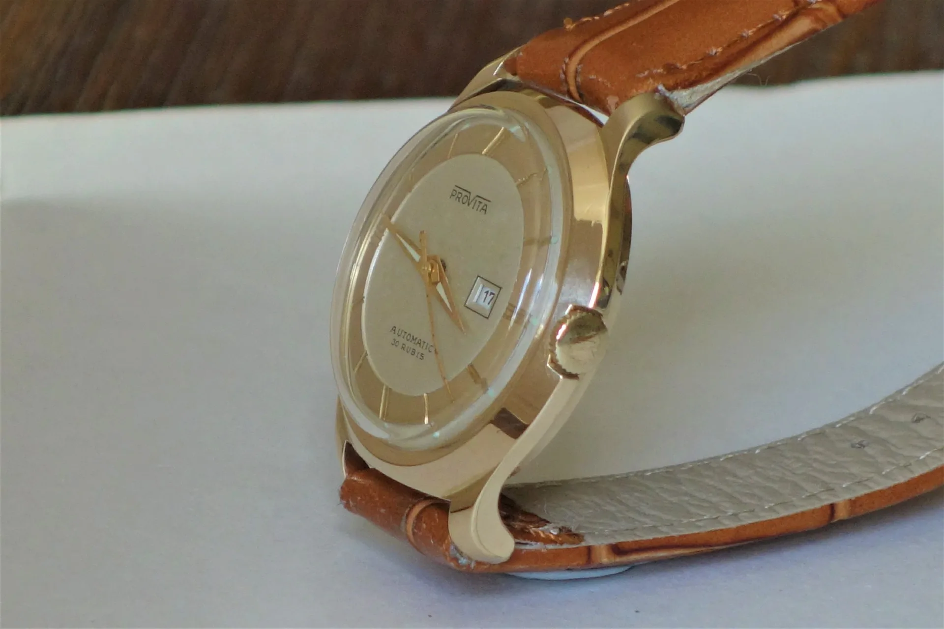 Automatik Armbanduhr beige Beige Armbanduhr mit rundem Zifferblatt und braunem Lederarmband.