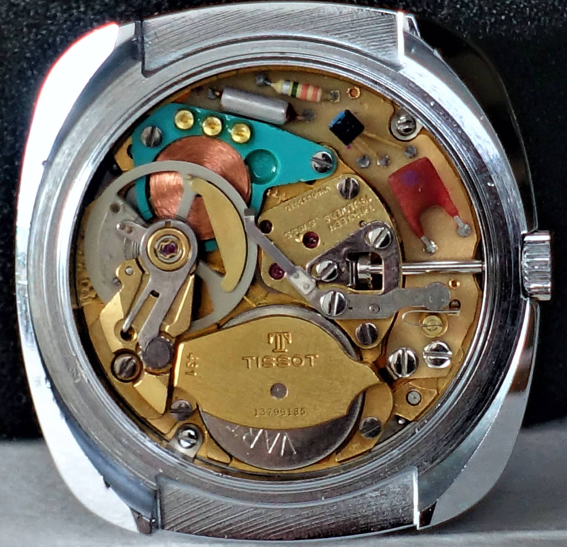 Elektronisches Uhrwerk von Tissot mit sichtbaren Bauteilen und goldfarbener Abdeckung.