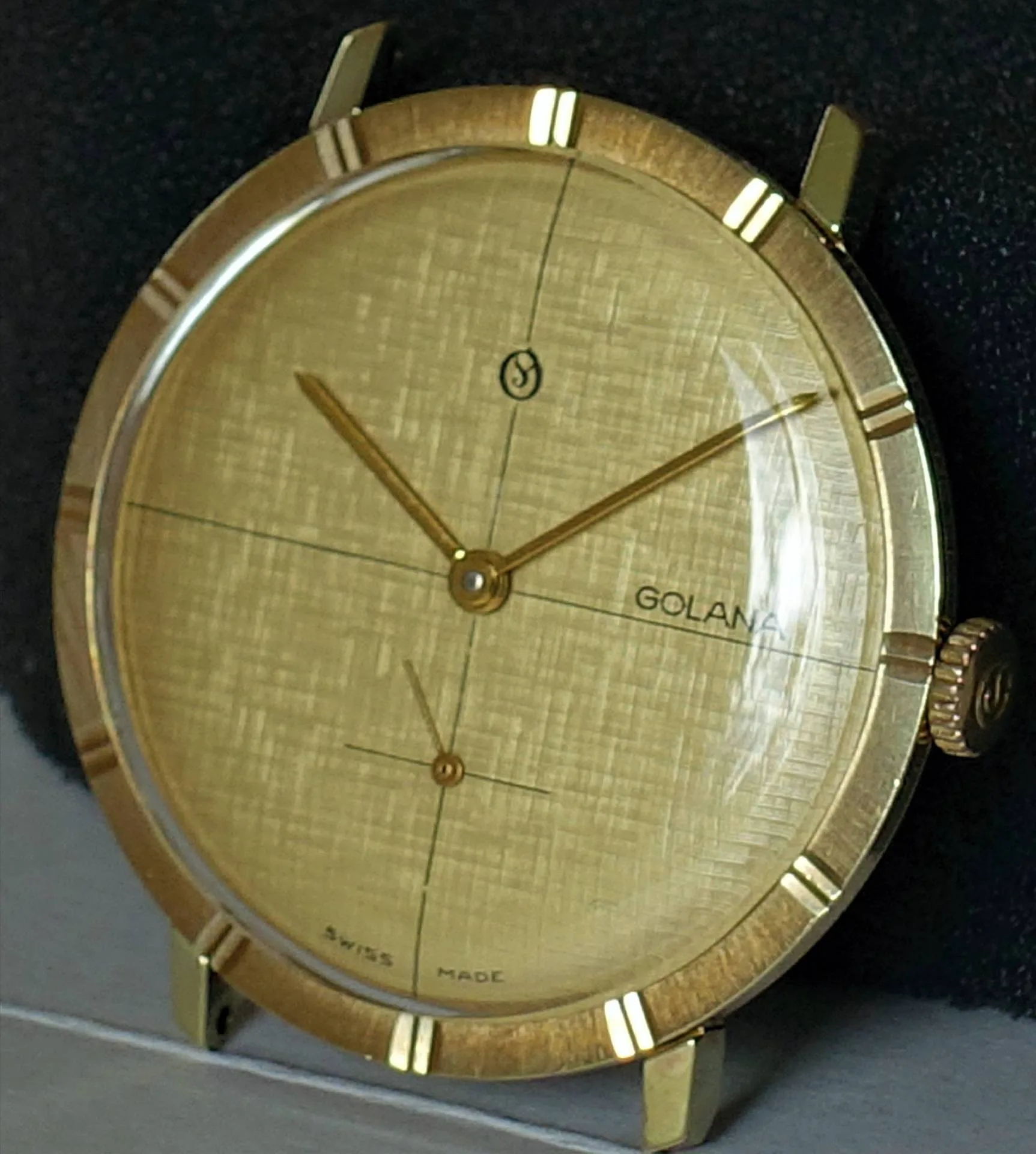 Golduhr mit Zifferblatt Runde Uhr mit goldfarbenem Gehäuse und Zifferblatt, goldenen Zeigern und feinen Linien auf dem Zifferblatt.