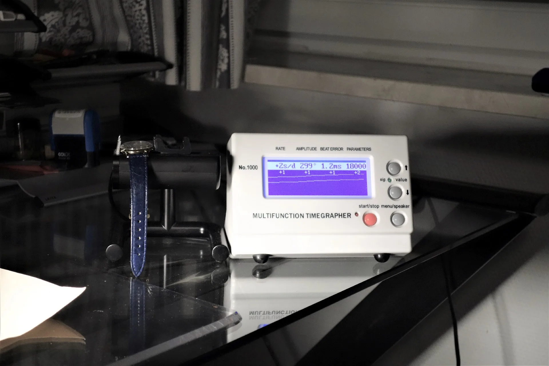 Weißes elektronisches Zeitwaagen Messgerät mit digitalem Display zur Überprüfung von mechanischen Uhren.