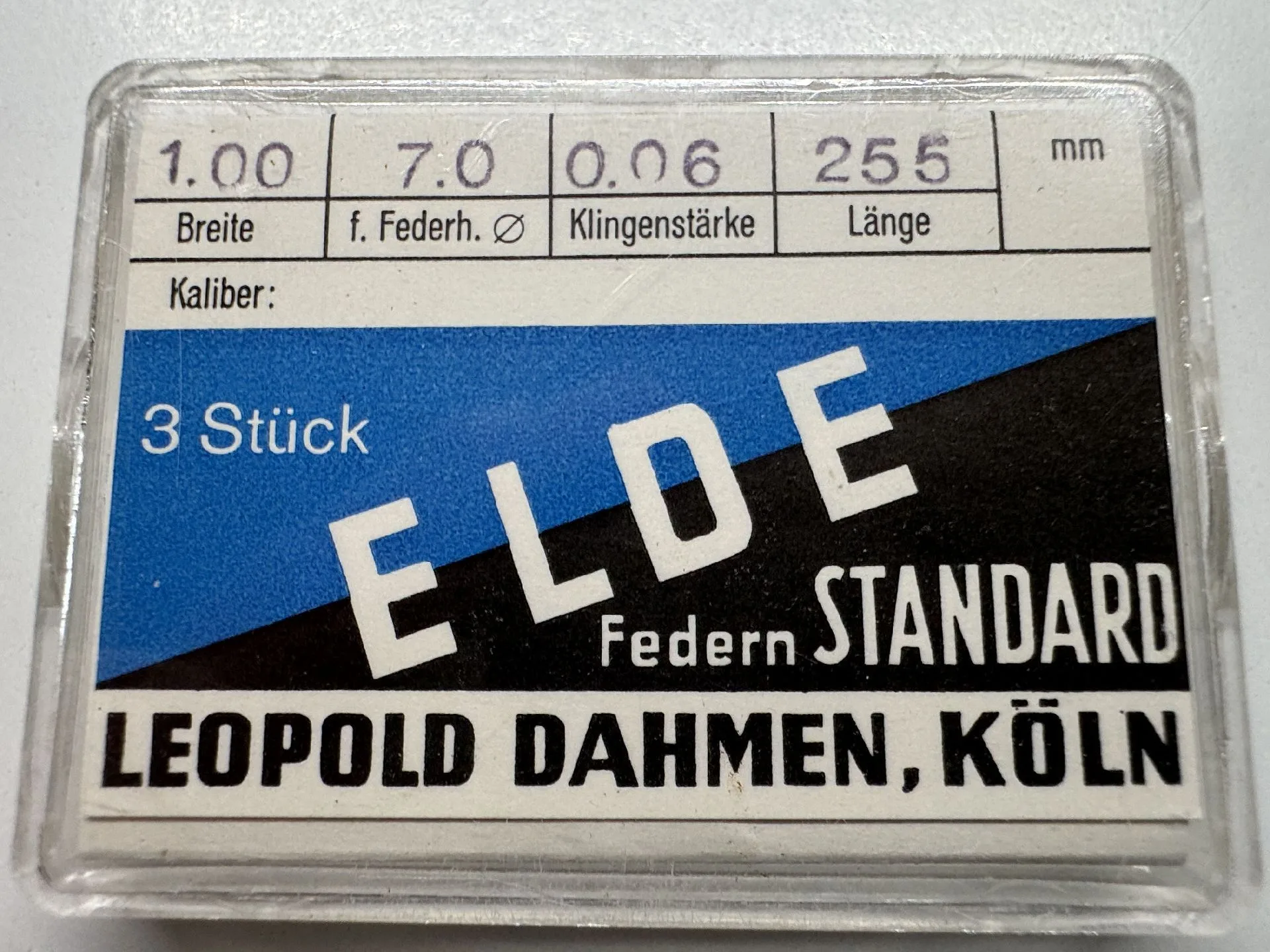 Verpackung mit drei Uhrwerk-Federn, 1,00 Millimeter breit und 255 Millimeter lang, von ELDE Leopold Dahmen Köln.