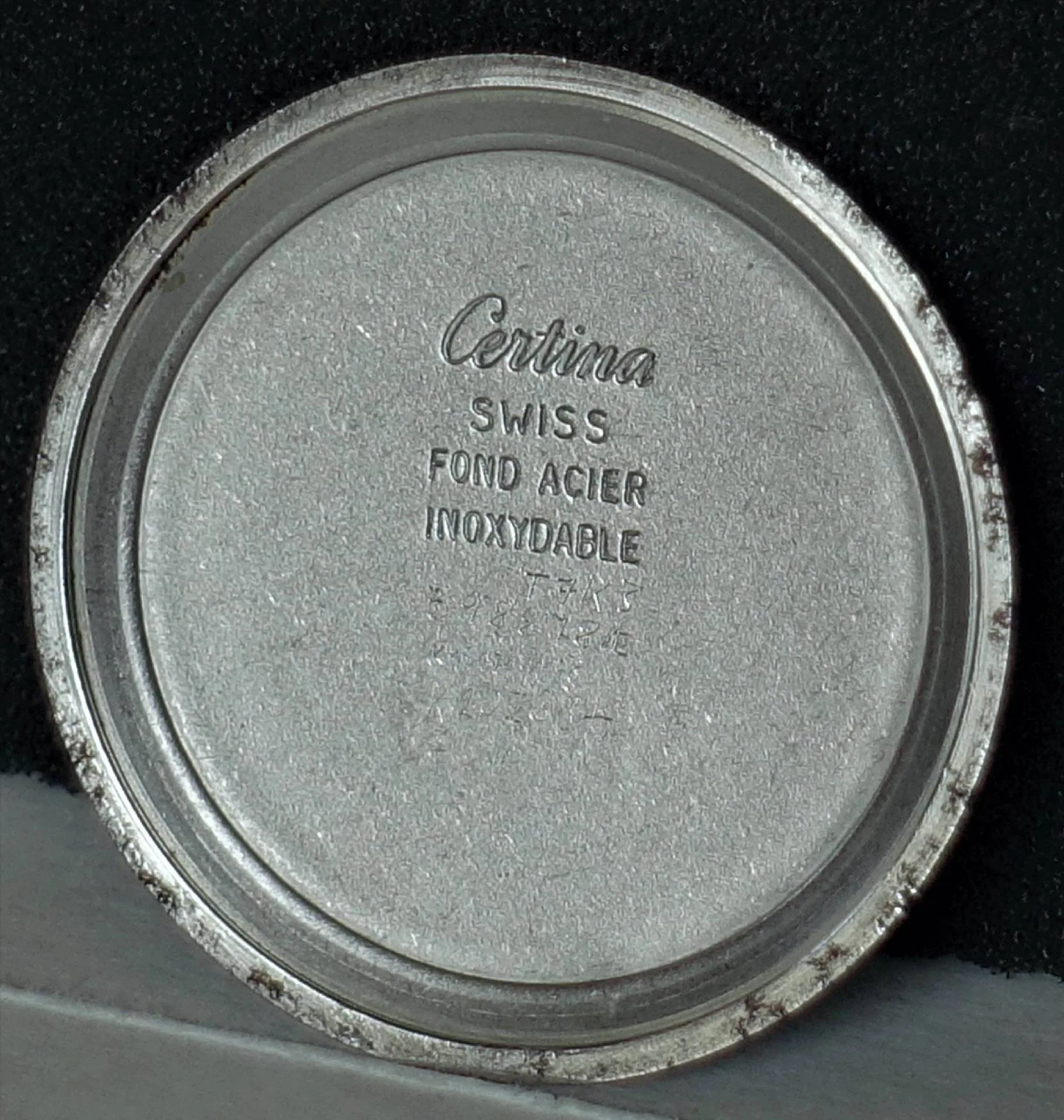 Runder silberfarbener Gehäuseboden einer Certina Uhr mit Prägung auf der Innenseite.