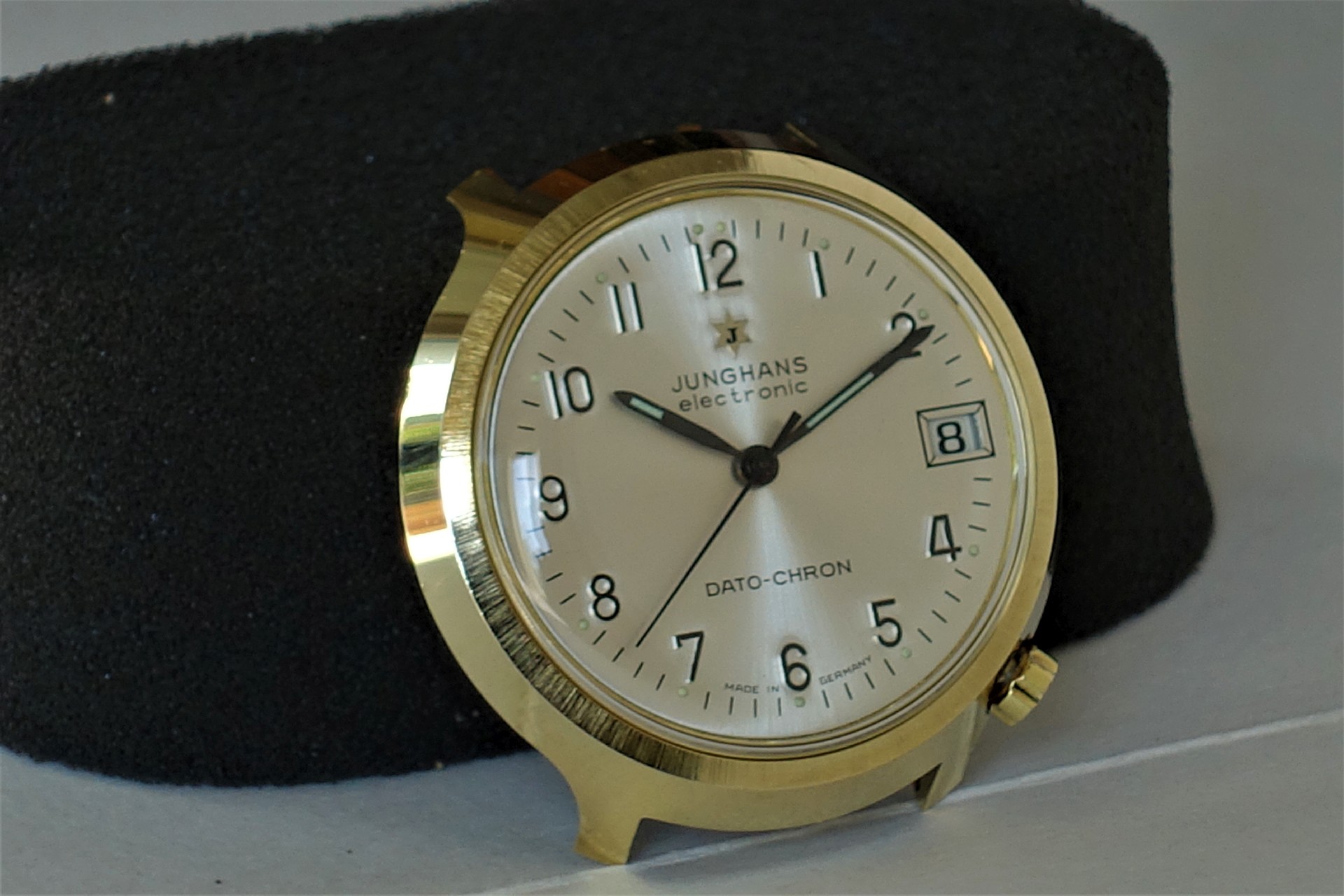 Helle Armbanduhr mit goldfarbenem Gehäuse und Datumsanzeige.