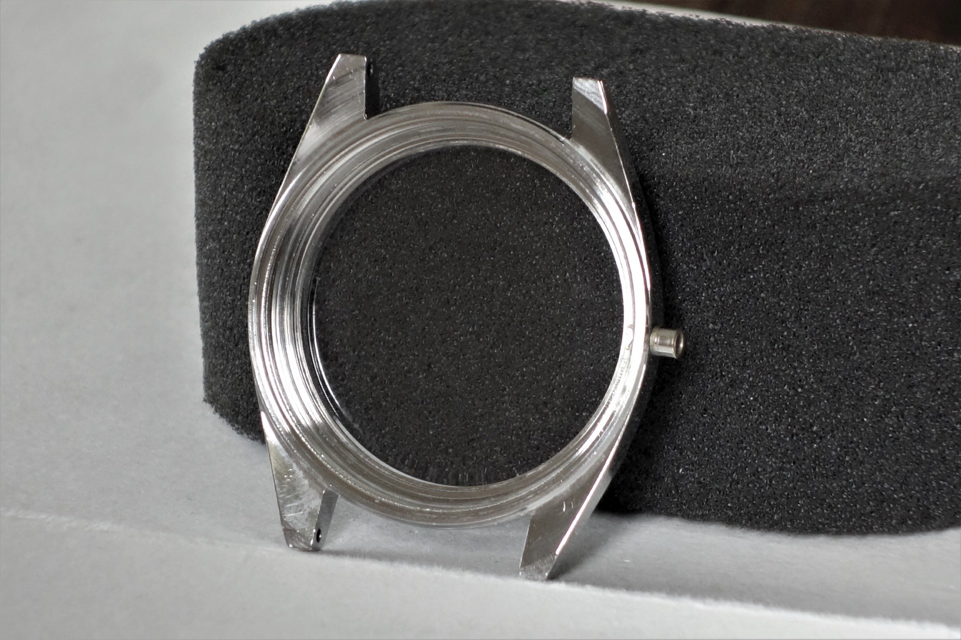 Rundes Uhrengehäuse in silberner Farbe ohne Uhrwerk und Glas.