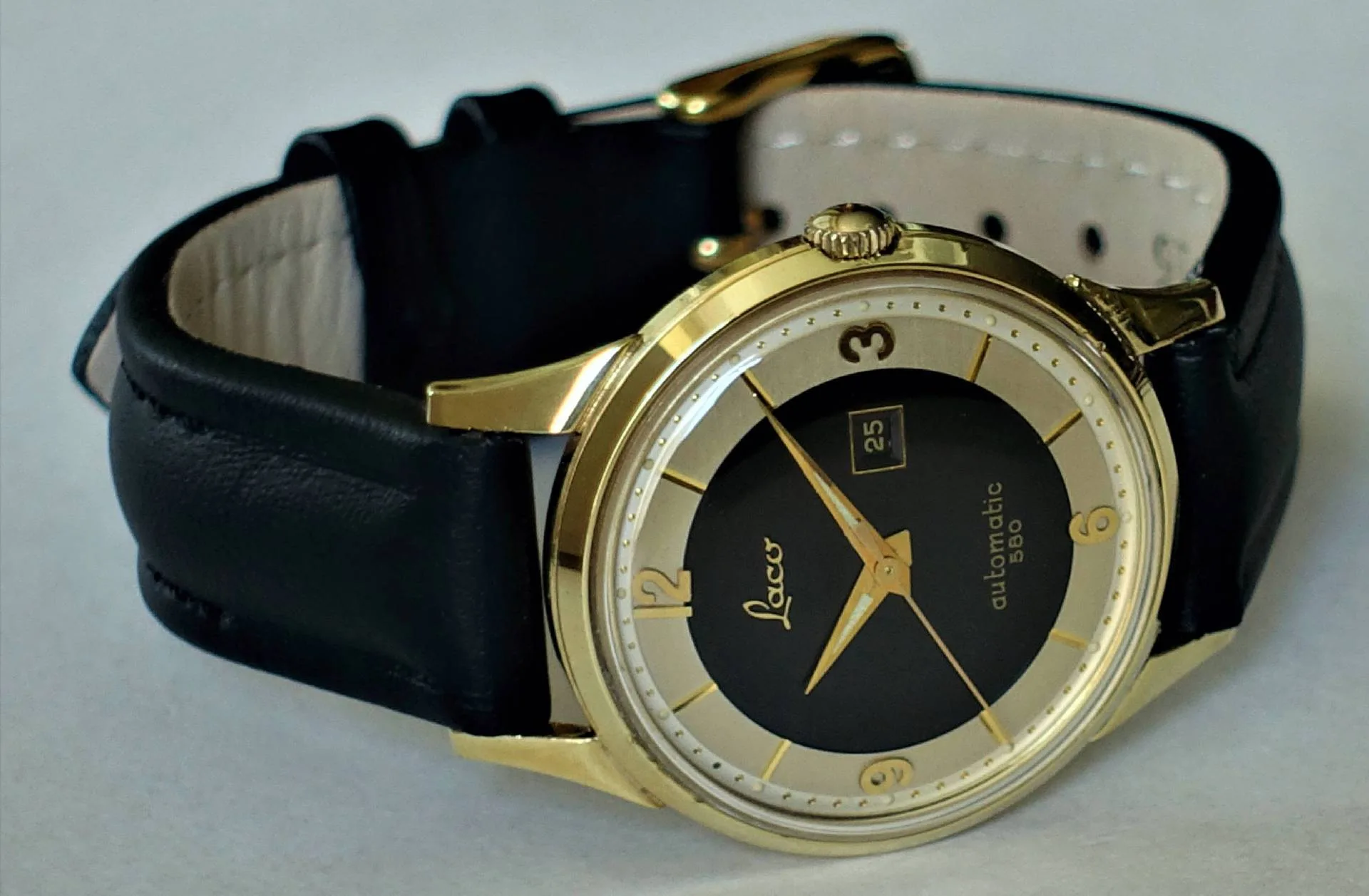 Armbanduhr schwarz goldfarben Schwarze Armbanduhr mit goldfarbenem Gehäuse und schwarzem Lederarmband.