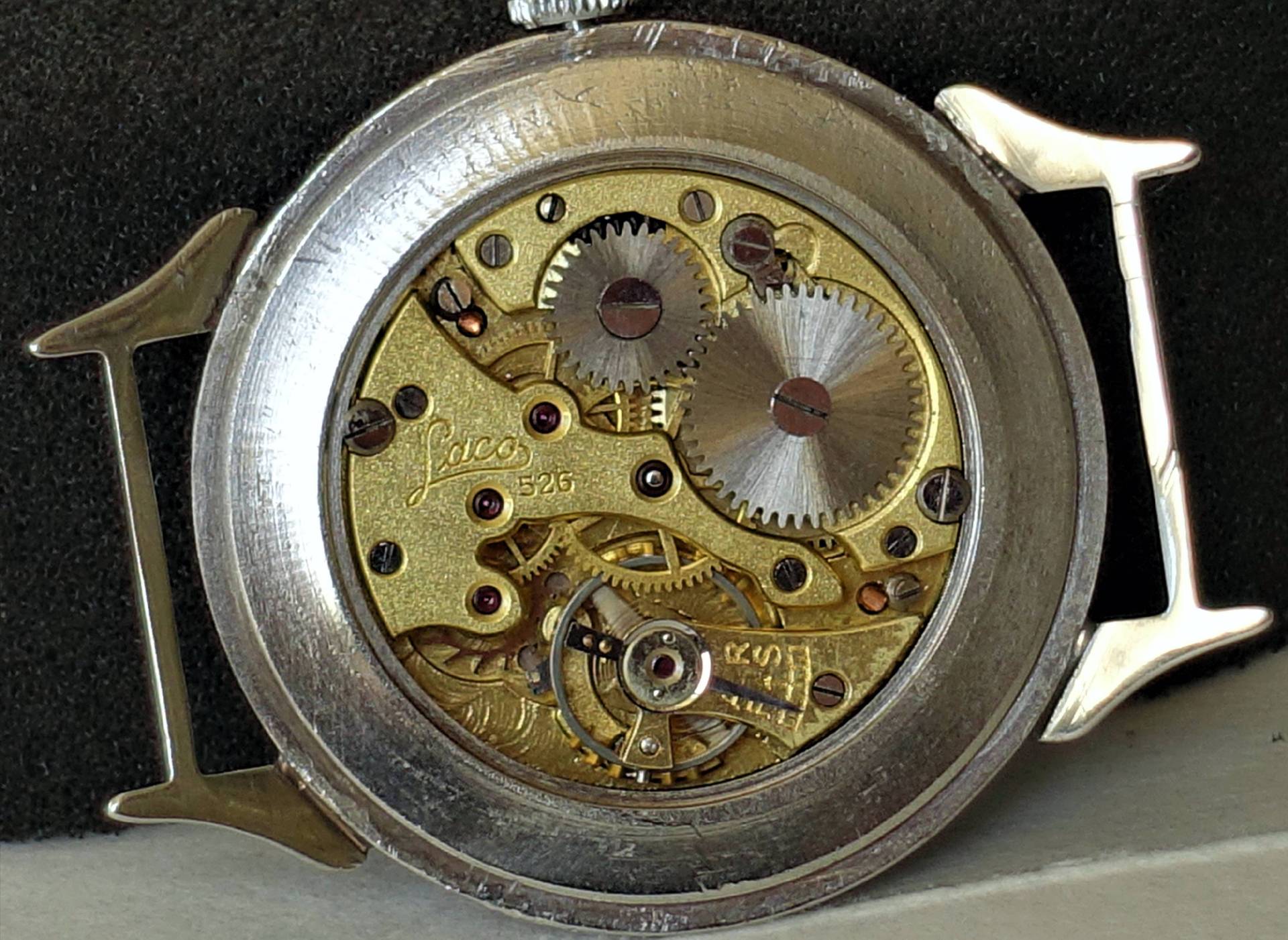 Mechanisches Uhrwerk Laco 526 in silberfarbenem Gehäuse mit sichtbaren Zahnrädern und Gravur.