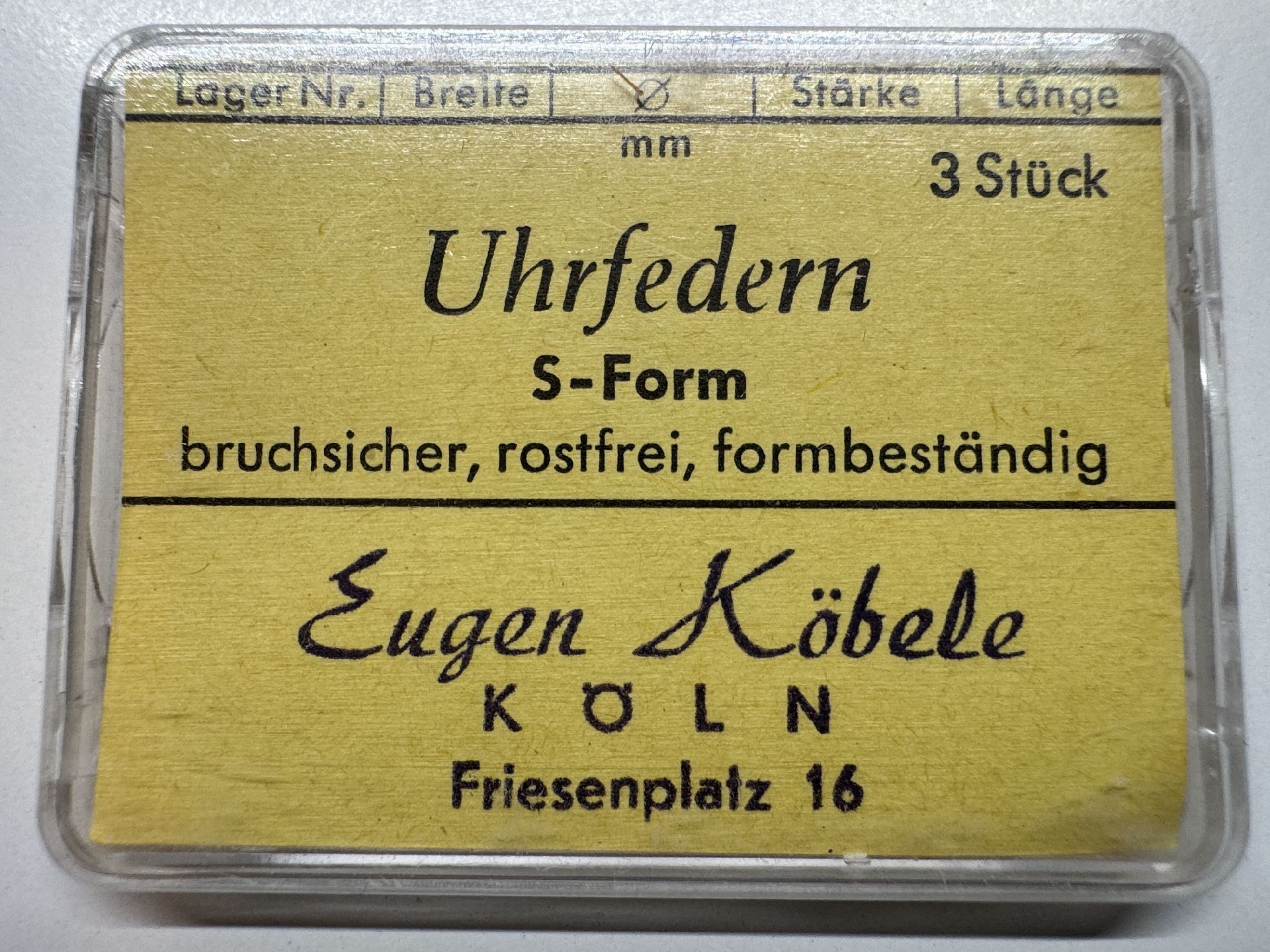 Gelbe Verpackung mit drei bruchsicheren, rostfreien Uhrfedern in S-Form.