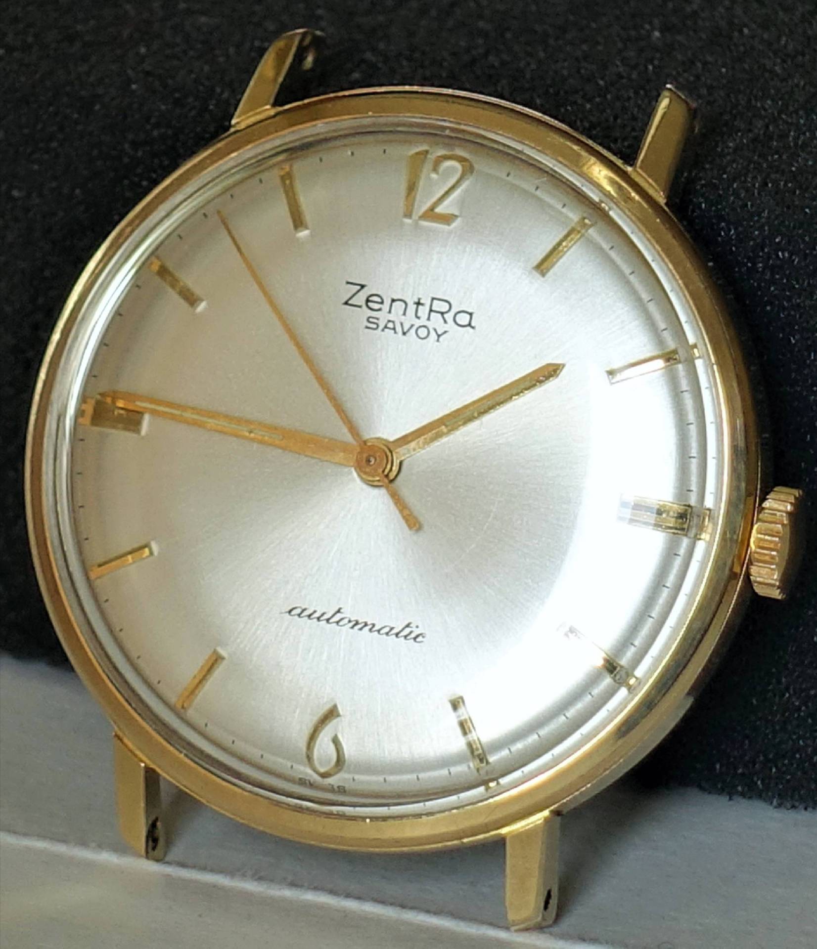 Goldfarbene Armbanduhr mit silbernem Zifferblatt und goldenen Zeigern.
