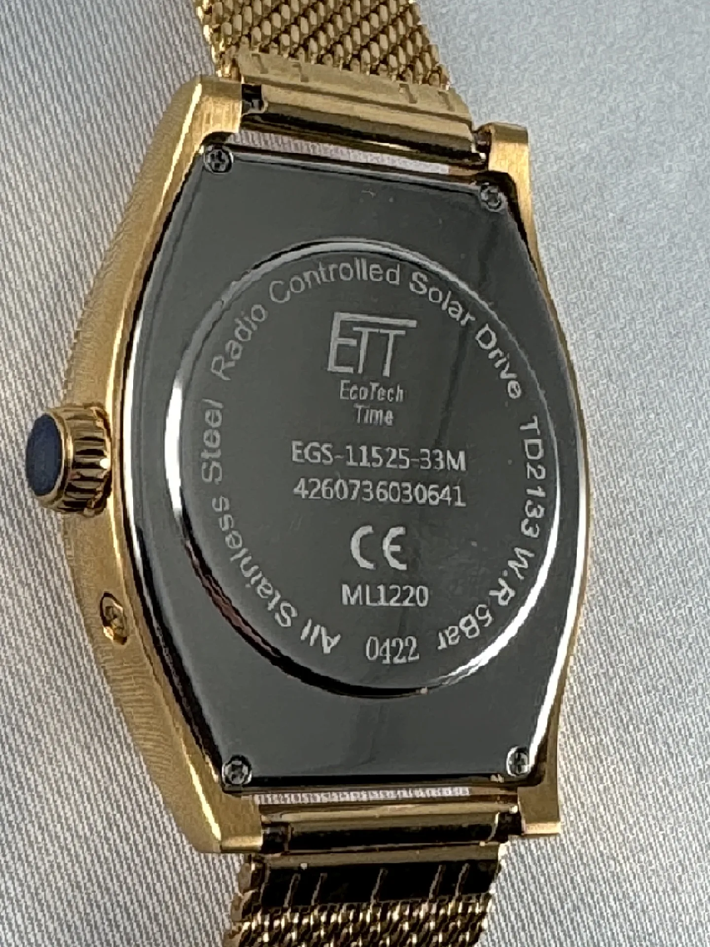 Rückseite einer goldfarbenen Funk-Solaruhr mit Edelstahlboden und Milanaise-Armband.