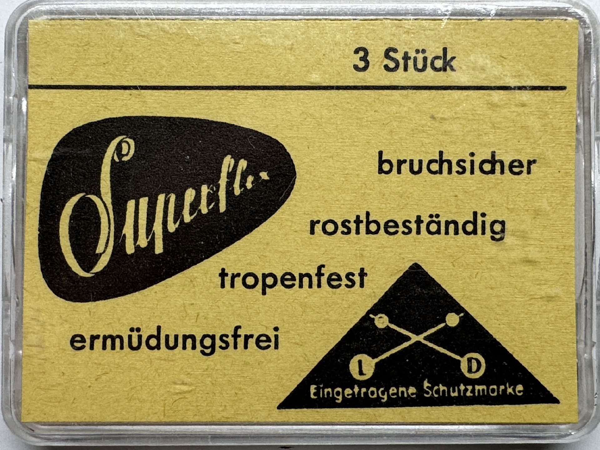 Gelbe Verpackung mit drei Federstegen für Uhren, Aufschrift "Superflex", mit Symbol und Produktmerkmalen.