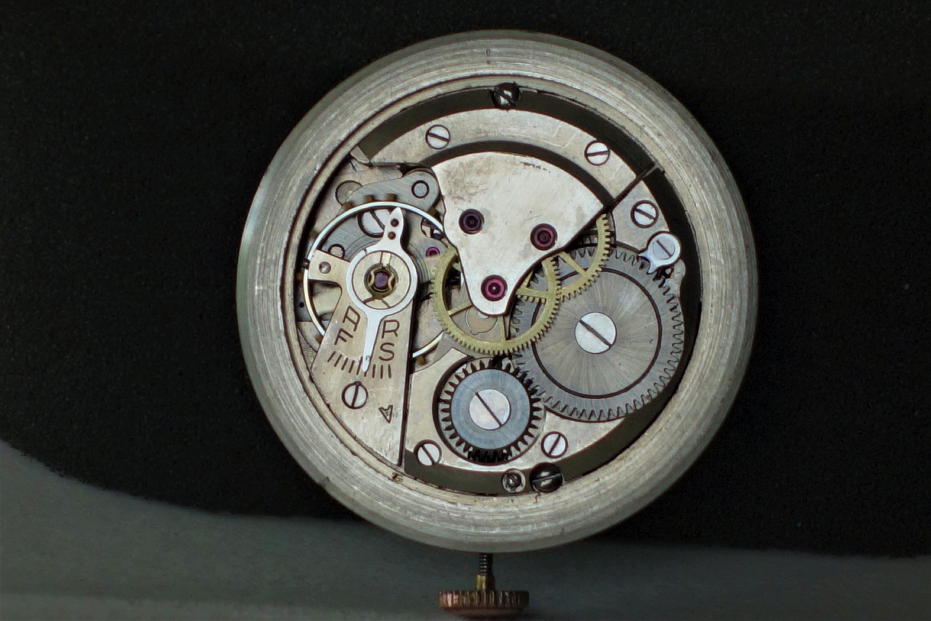 Mechanisches silberfarbenes Uhrwerk mit sichtbaren Zahnrädern und Schrauben.