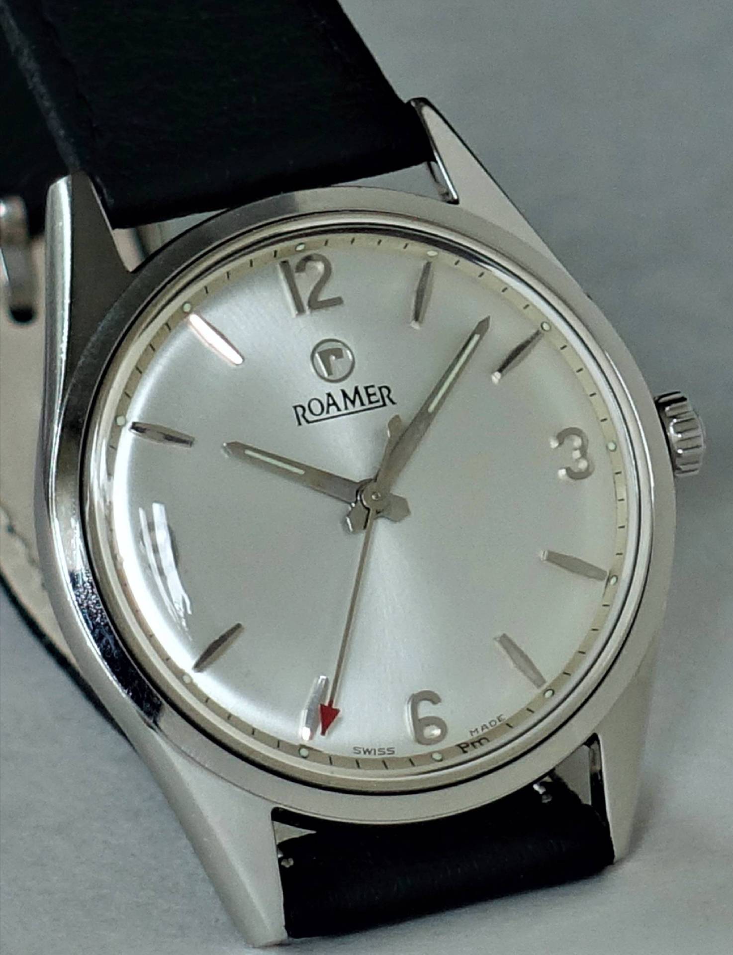 Silberfarbene Armbanduhr mit schwarzem Armband und schlichtem Zifferblatt der Marke Roamer.