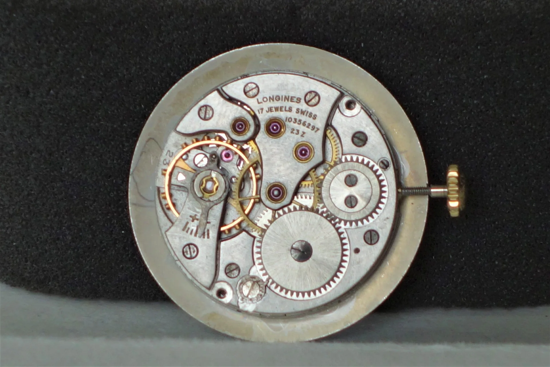 Uhrwerk Longines mechanisch Silberfarbenes mechanisches Uhrwerk von Longines mit sichtbaren Zahnrädern und goldfarbener Krone.