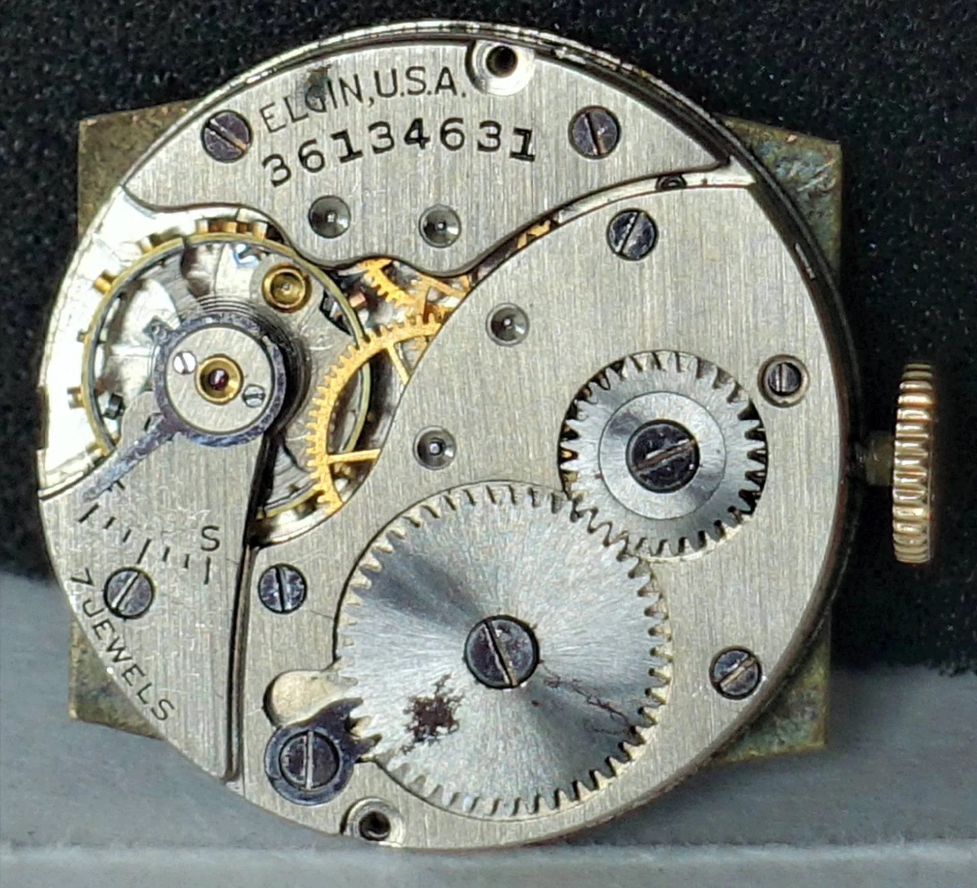 Silber-goldenes Uhrwerk mit Zahnrädern Das Bild zeigt ein mechanisches Uhrwerk mit silberfarbenen und goldfarbenen Zahnrädern sowie sichtbaren Schrauben und Gravuren.