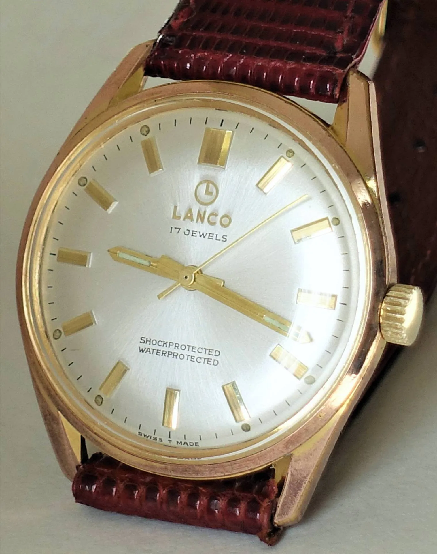 Lanco Armbanduhr goldfarben Goldfarbene Armbanduhr mit silbernem Zifferblatt und braunem Lederarmband.