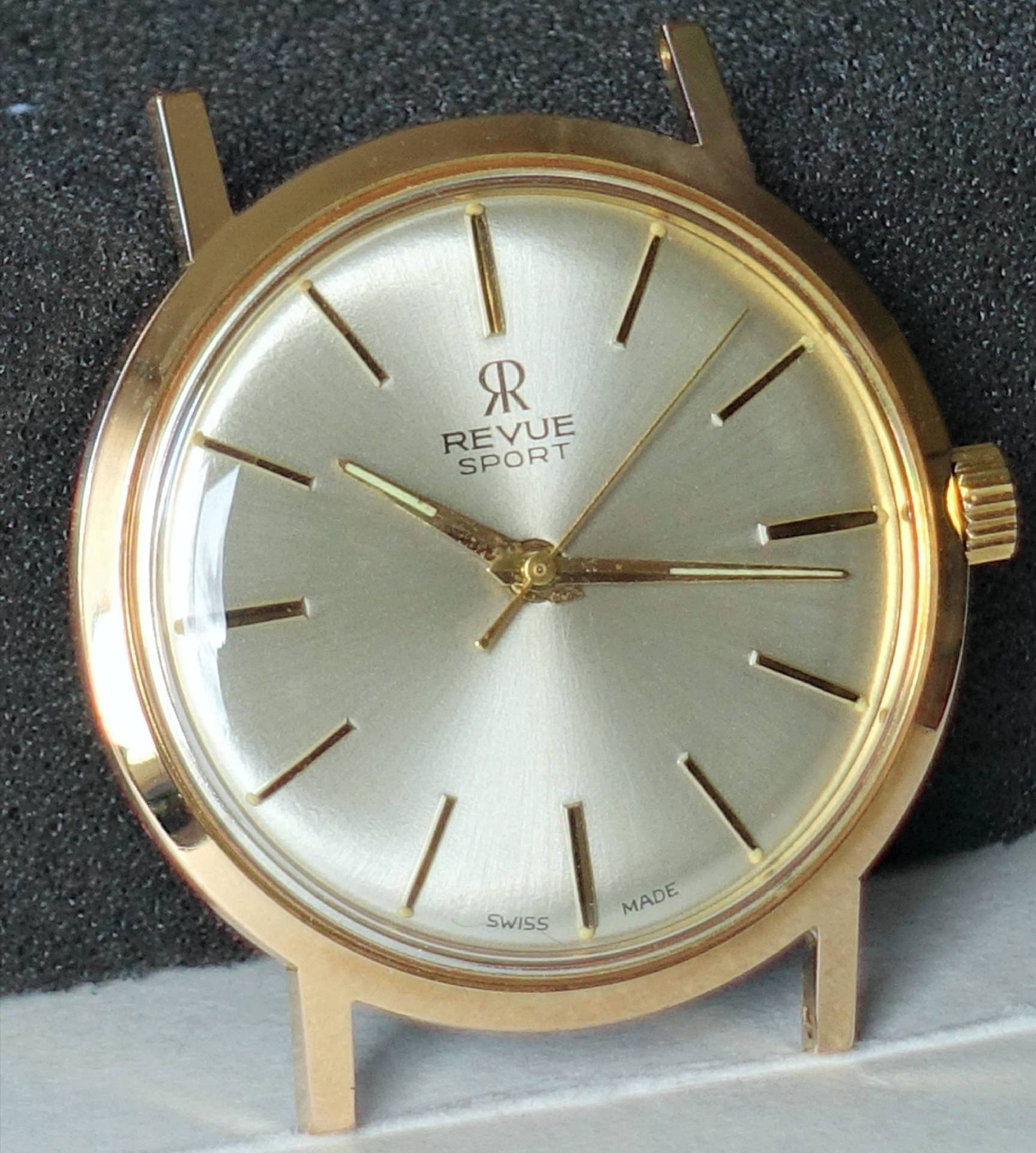 Goldfarbene Armbanduhr mit silbernem Zifferblatt und schlichten Indizes.