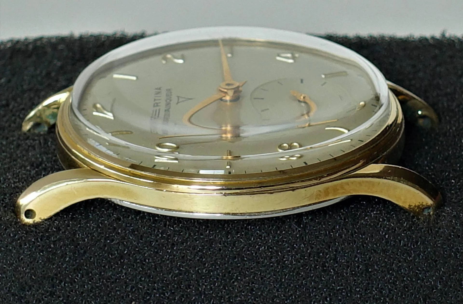 Goldfarbene Armbanduhr mit hellem Zifferblatt und goldfarbenen Zeigern.