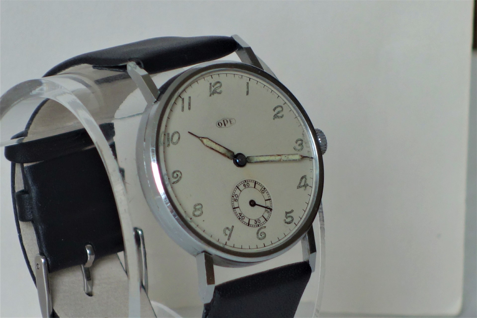 Silberfarbene Armbanduhr mit hellem Zifferblatt und schwarzem Armband.