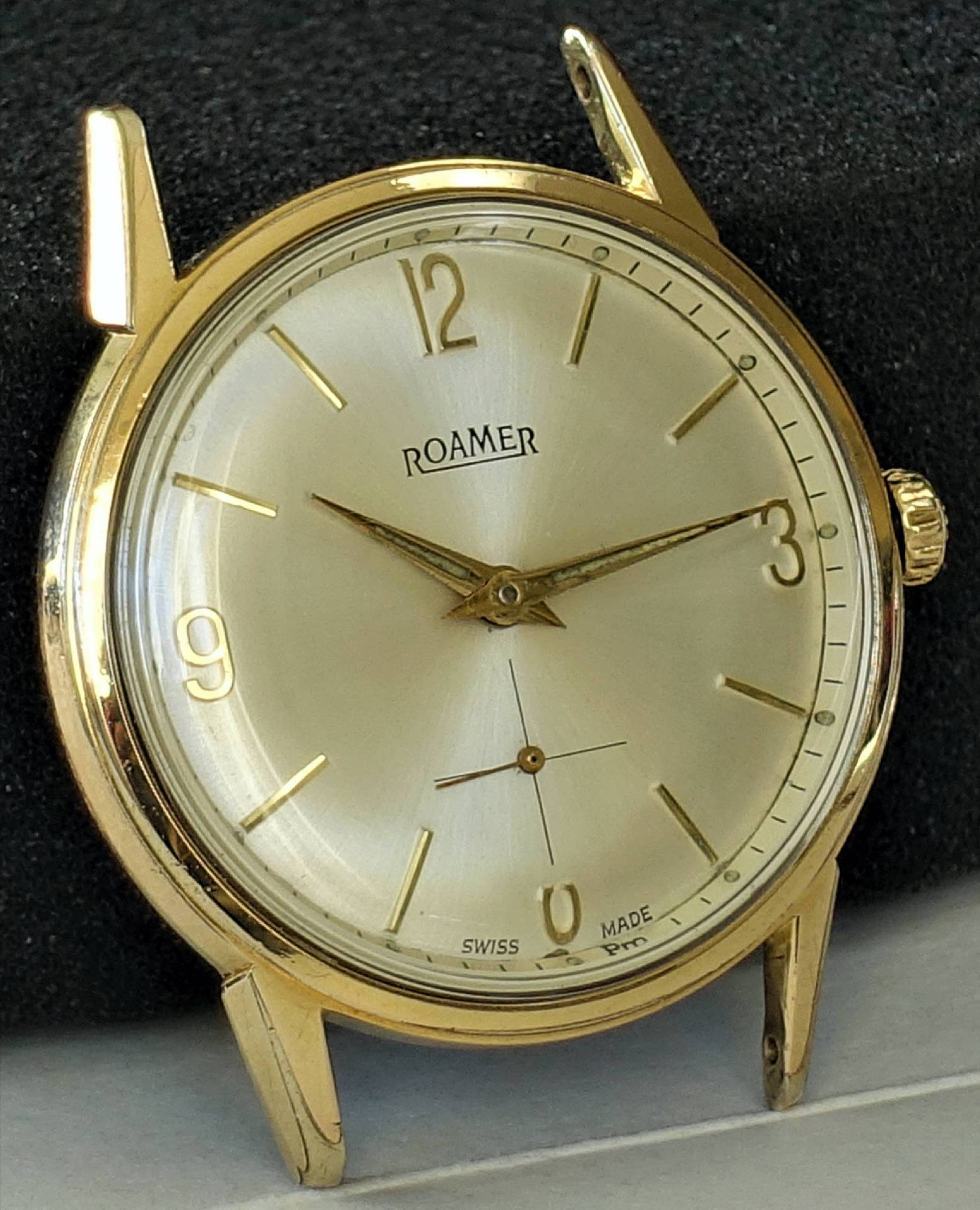 Goldfarbene Roamer Armbanduhr mit hellem Zifferblatt und goldenen Indizes.