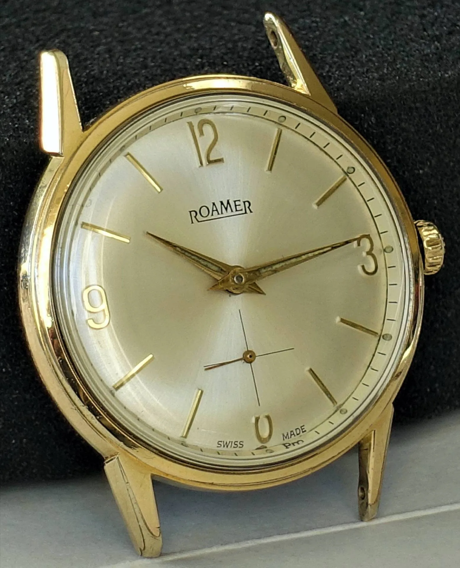 Goldfarbene Roamer Armbanduhr mit hellem Zifferblatt und goldenen Indizes.