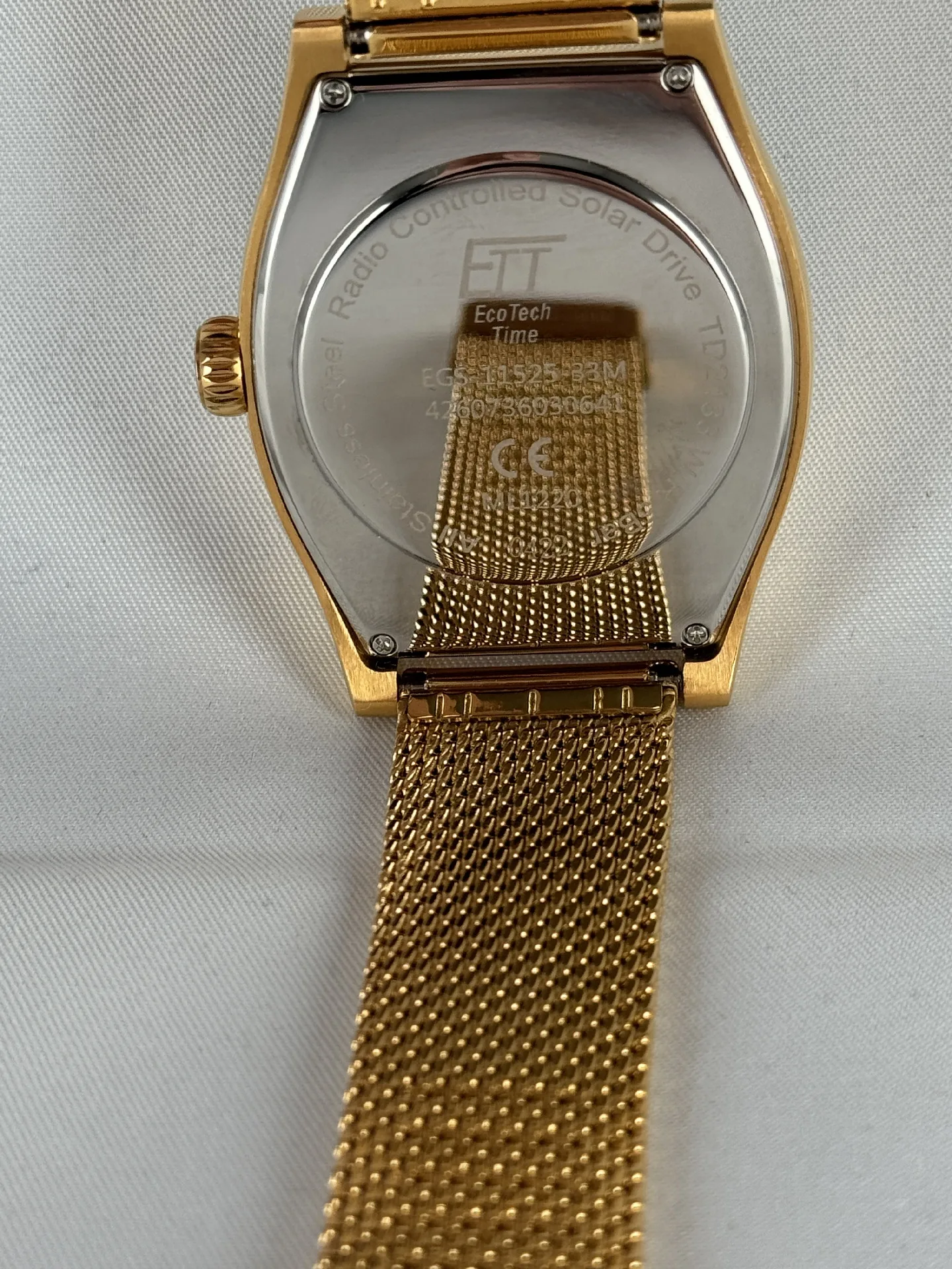 Rückseite einer goldfarbenen Funkarmbanduhr mit Edelstahlgehäuse und Milanaise-Armband.